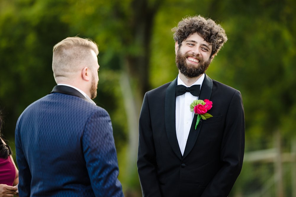 Candid photo of groom laughing during the ceremony at Cana Vineyards 