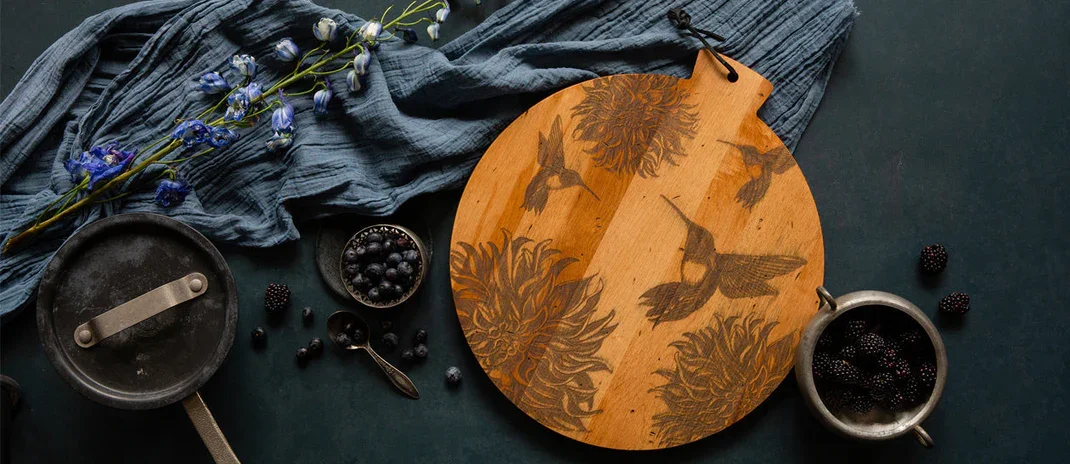 JK-ADAMS-COLLECTION-IMAGE-ARTISAN-MAPLE-ROUND-SERVING-BOARD-LAURA-ZINDEL-NUTHATCH-LIFESTYLE-BOARD-WITH--PEACHES-AND-FLOWERS.jpg.webp