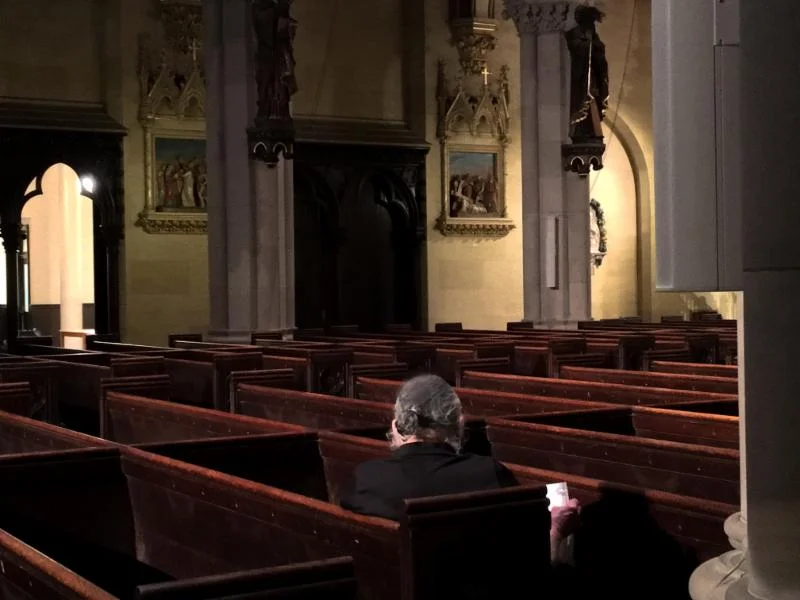 A visitor praying in the church .