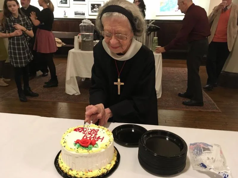 Sister Laura Katharine cutting her birthday cake after Solemn Mass