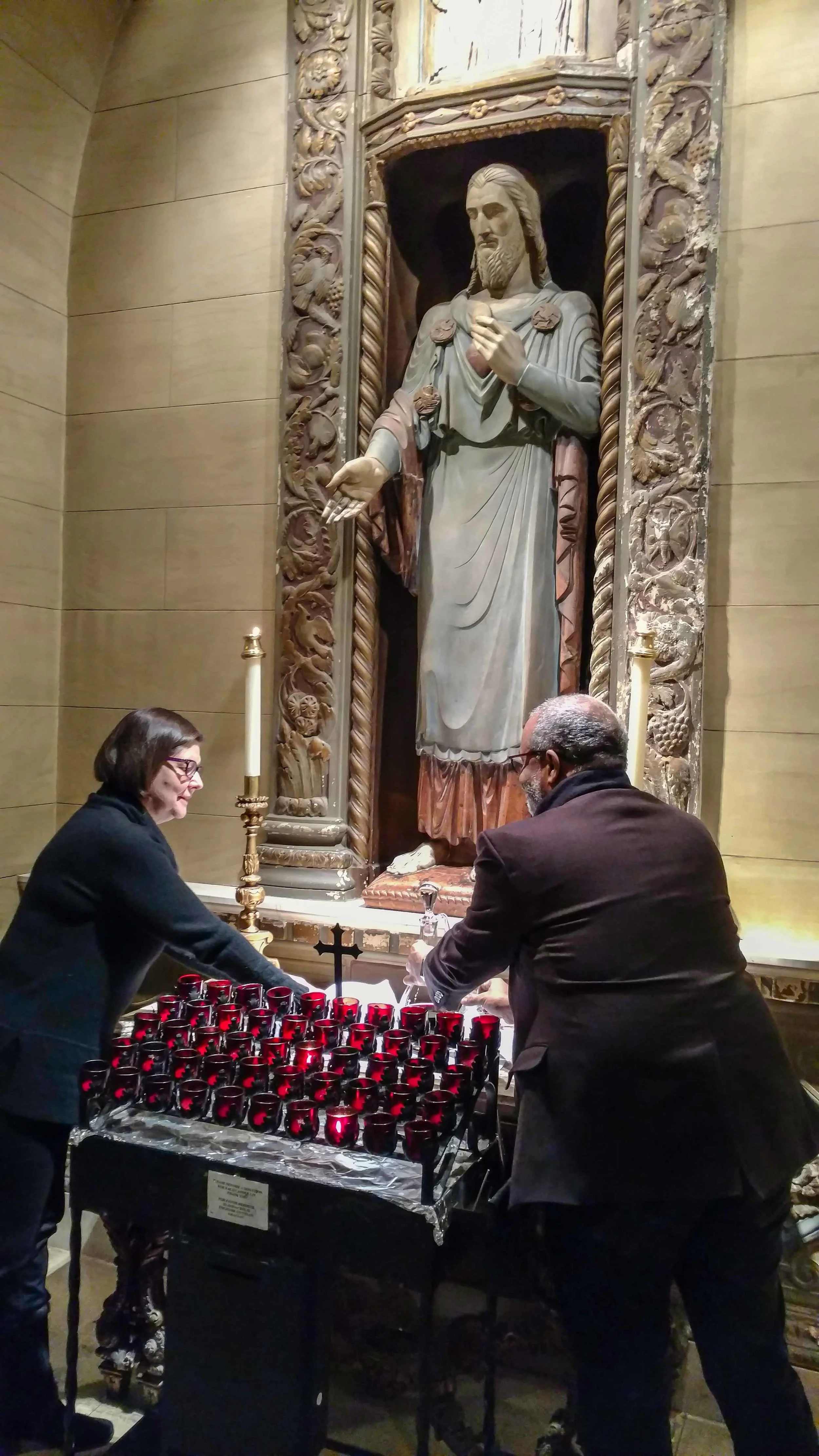 Ushers Renee Pecquex and Blair Burroughs collect the bread and wine at the Sacred Heart Shrine before the preparation of the gifts.