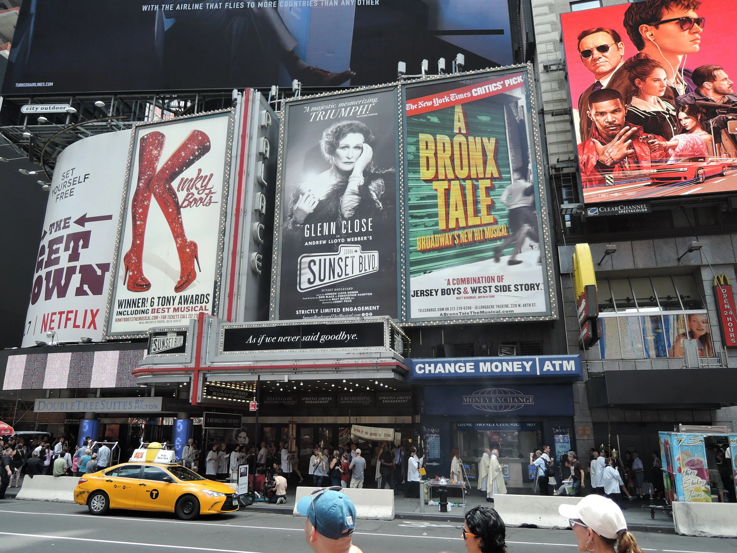 The Procession is returning to the church beneath the billboards on Seventh Avenue between 46th and 47th Streets. Note the barriers in place throughout the square to help safeguard pedestrians