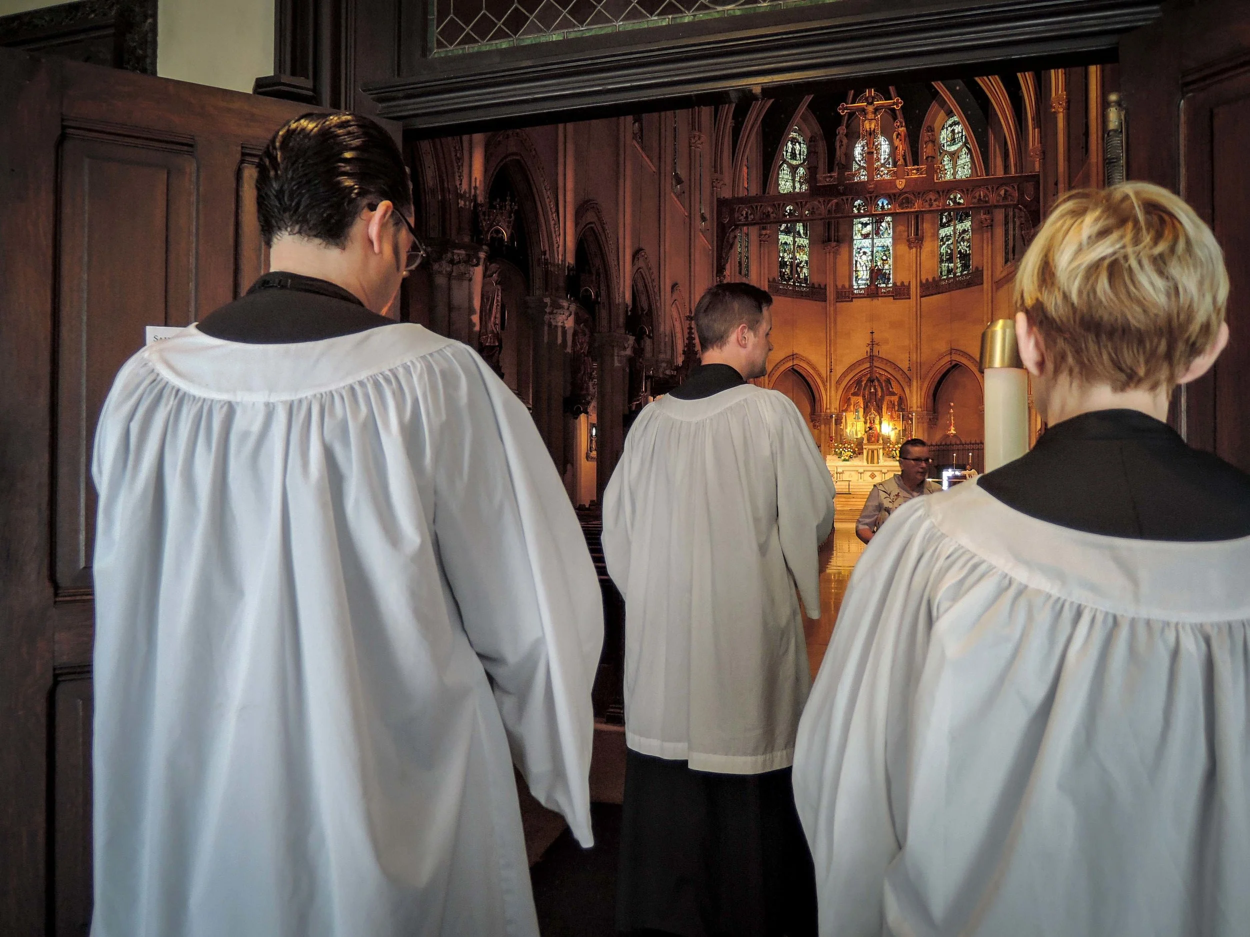 The thurifer (Clark Mitchell, center) and the torches (Ric Miranda and Ingrid Stellen) lead the ushers at the presentation of the gifts. Usher Pat Hoffman is in the background.