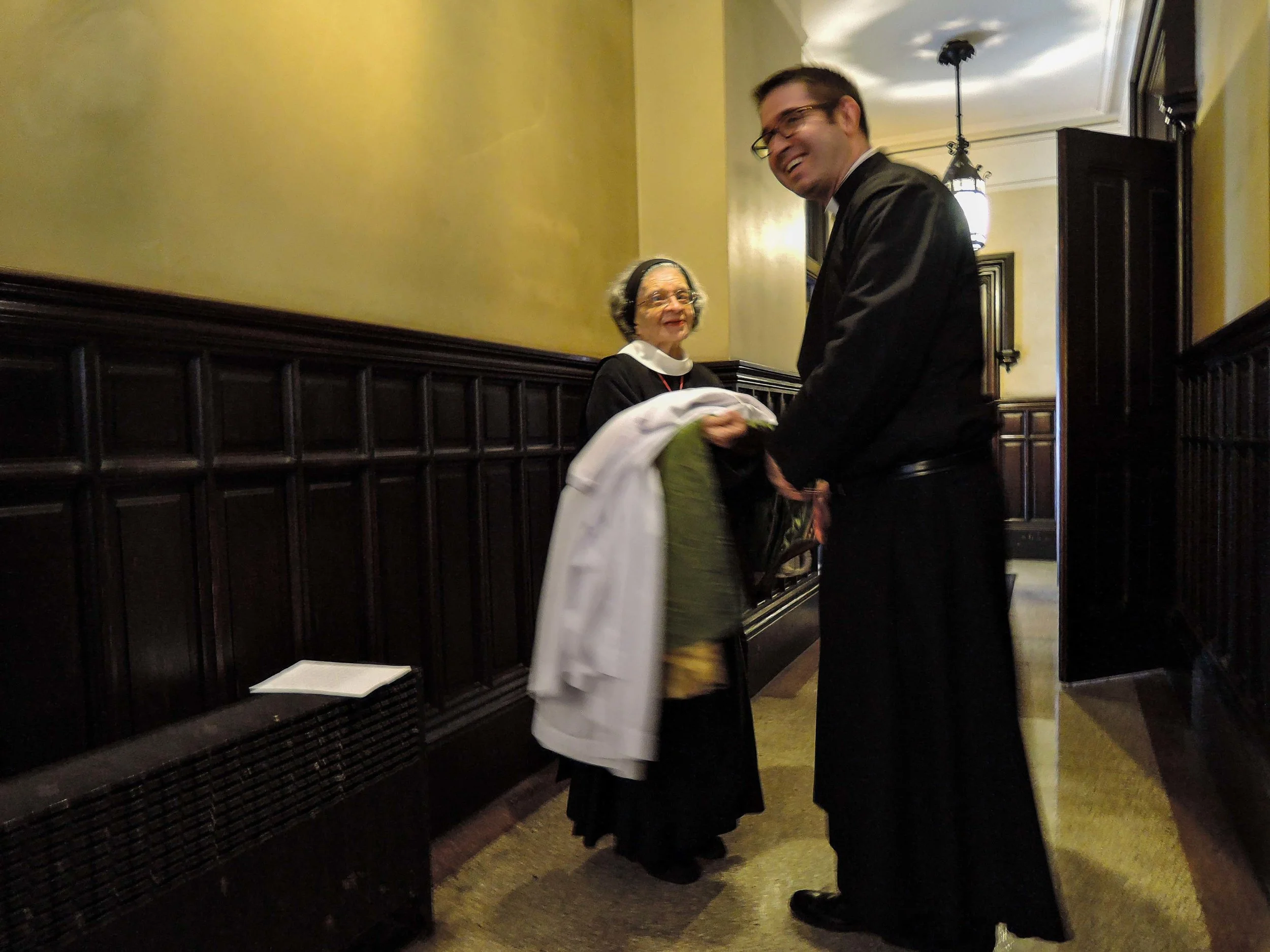 Sr. Laura Katharine assists Fr. Jacobson with his vestments after Mass.