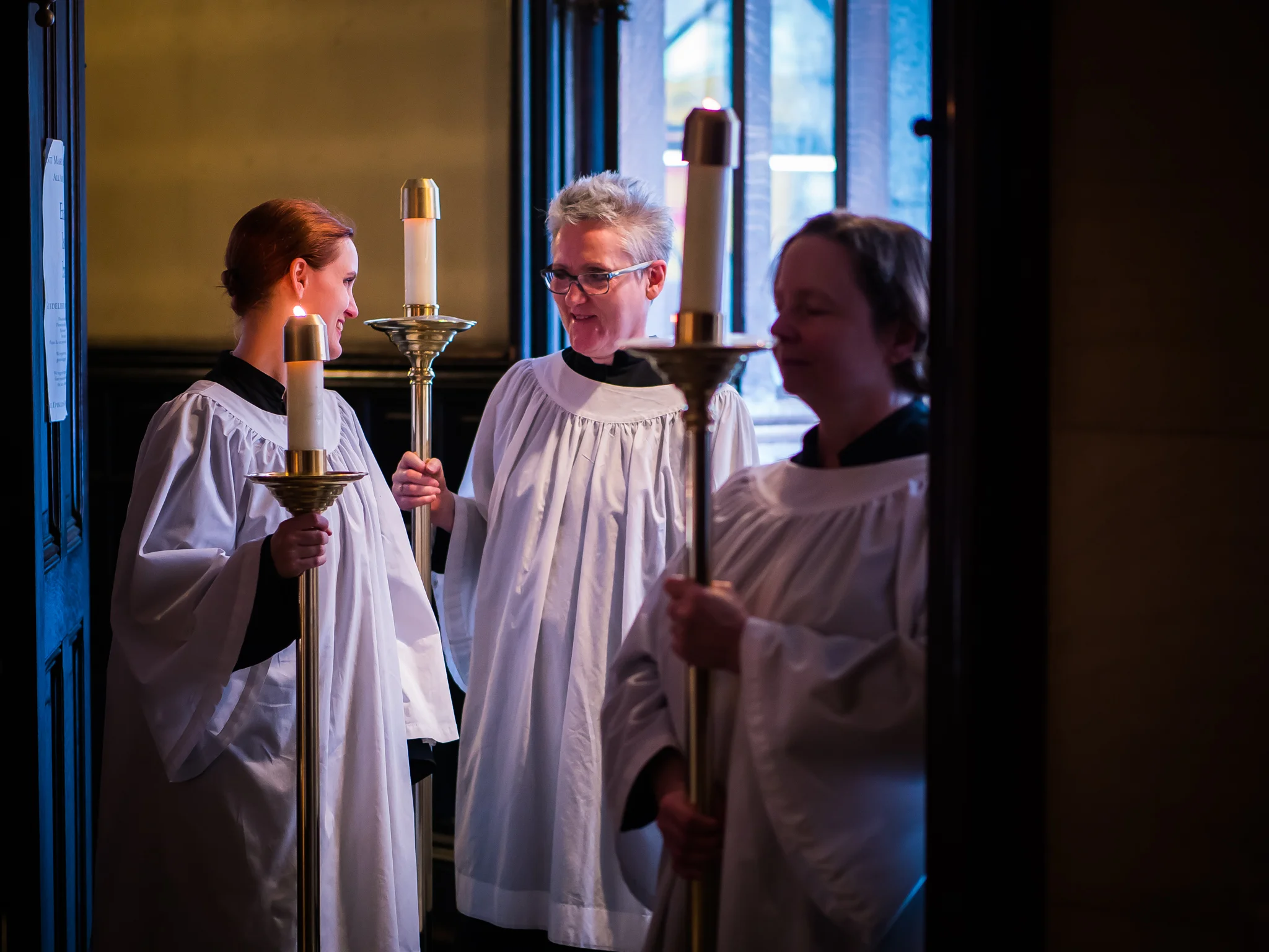 Behind the scenes: Grace Mudd (L), Marie Rosseels, and Marie Postelwate waiting for the procession of gifts to begin. Photo by Ricardo Gomez