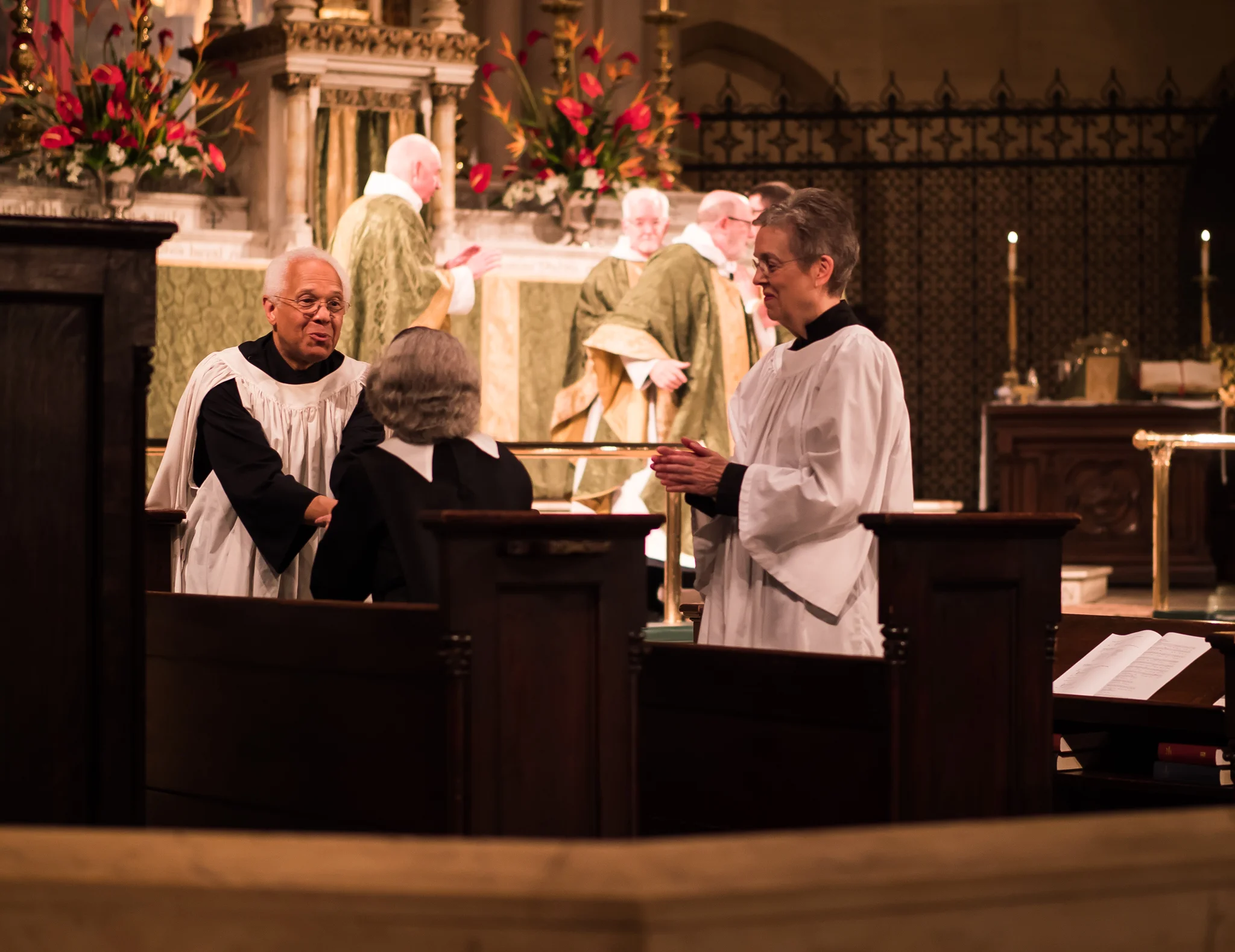 Dr. David Hurd (L), Sr. Laura Katharine, C.S.J.B., and MaryJane Boland exchange the peace on Sunday, August 19. Photo by Ricardo Gomez