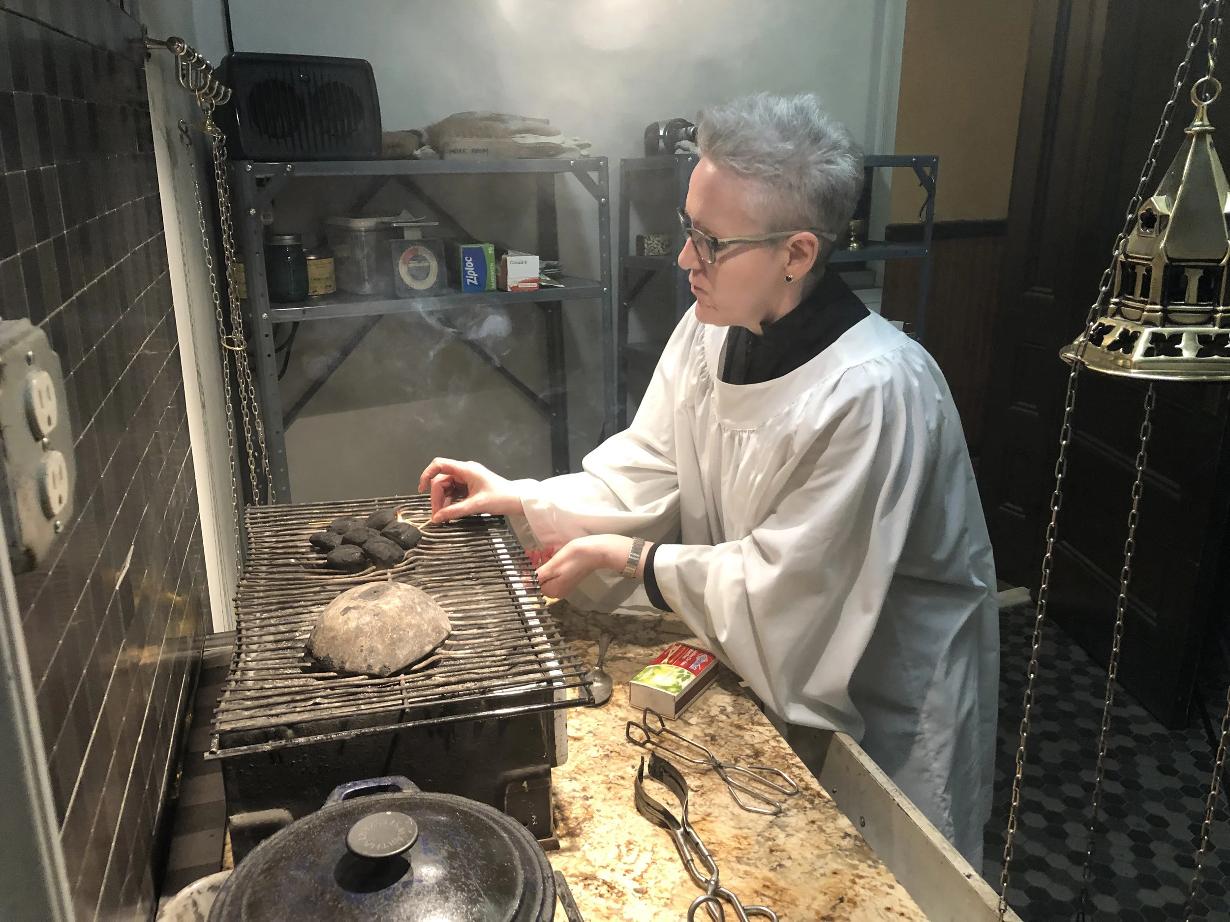 Marie Rosseels, thurifer, prepares coals for the proclamation of the gospel. Photo: Brendon Hunter