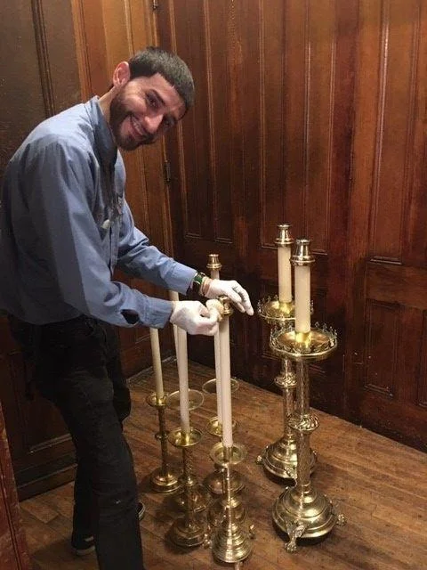 Sexton Shalim Peña prepares candles for Pentecost. Photo: Renee Pecquex