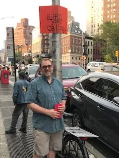 The sign above reads "Fulfill your calling": Br. Damien on a recent trip to Greenwich Village. Photo: Jay Smith