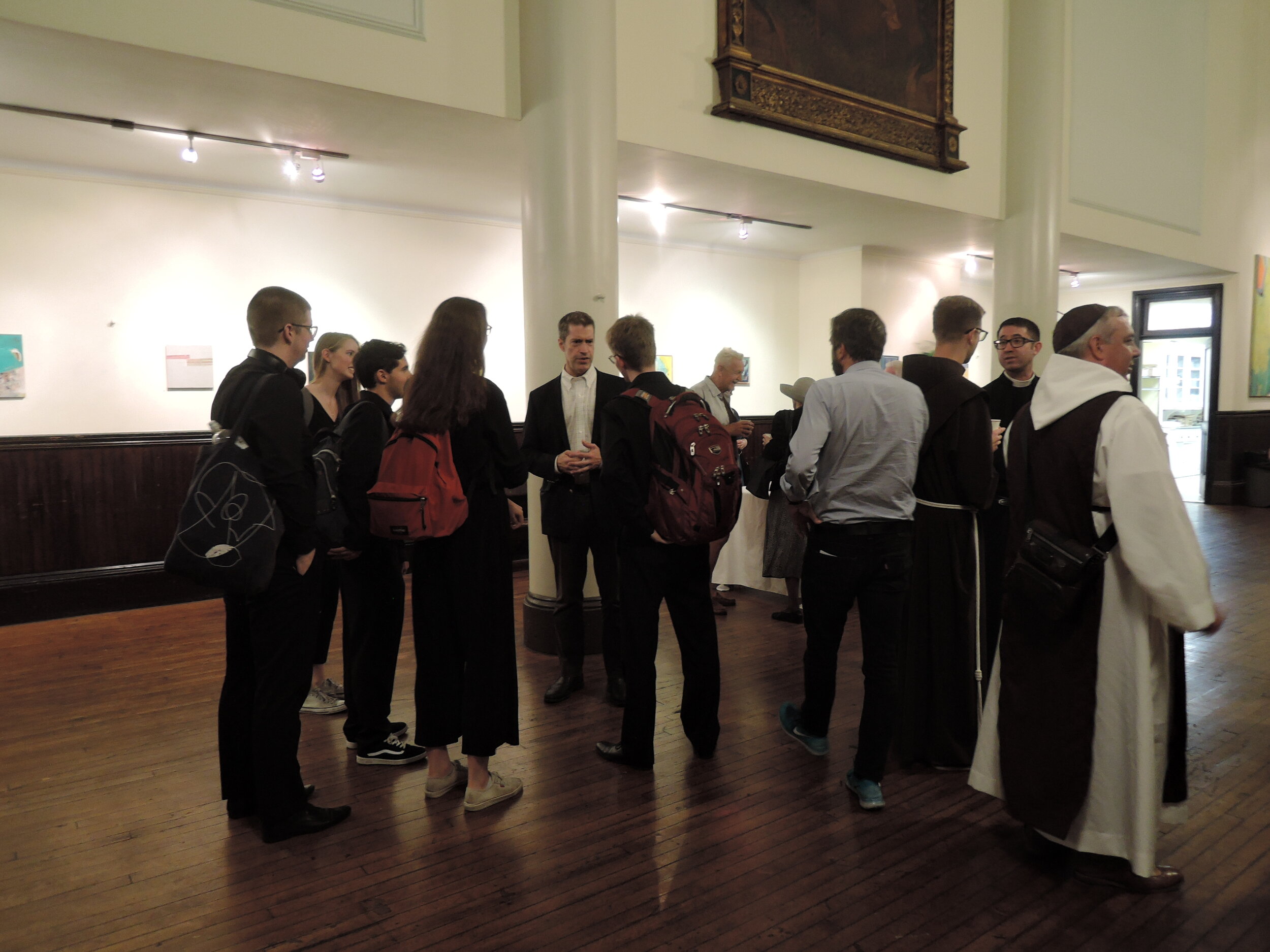 Dr. Mark Risinger (center), an alumnus of the Chapel Choir of Emmanuel College and vice-president of Saint Mary's Board of Trustees, speaks with choristers at coffee following the Eucharist. Photo: Grace Mudd