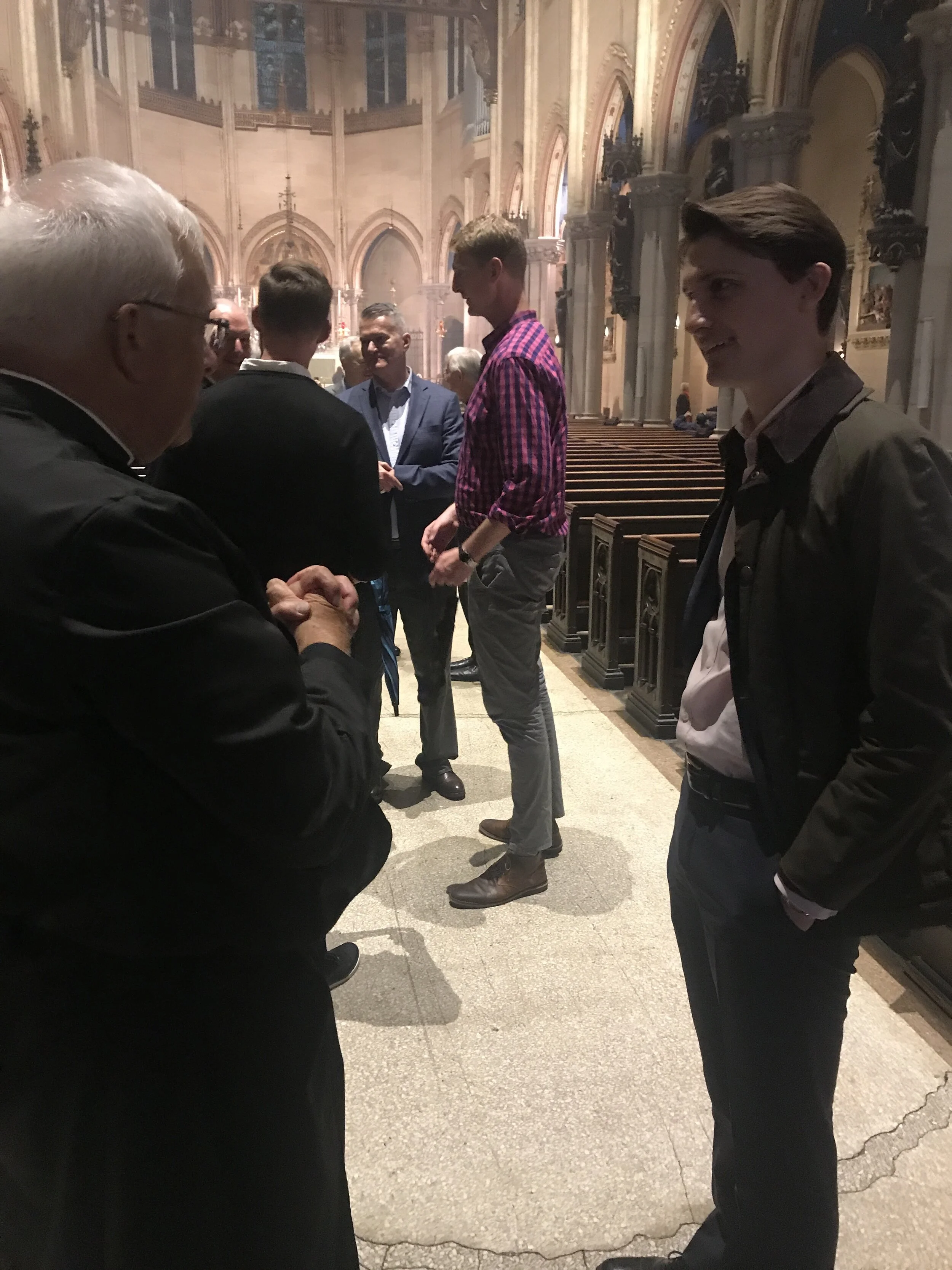 Parishioner Adam Morrow speaking with Father Powell after the Mass. Adam is now working in London, UK. Photo: Clark Mitchell