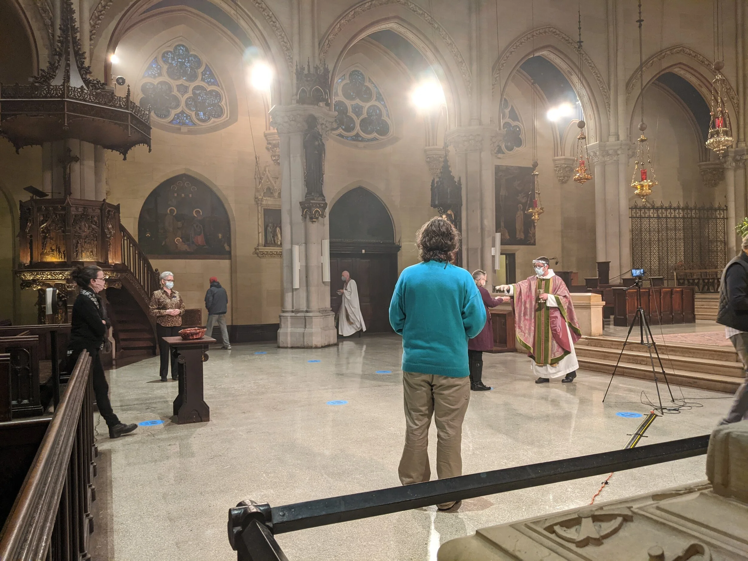 The Ministration of Holy Communion. in the side aisle, Father Gerth can be seen taking Communion to the organist and the cantor. Photo: Grace Mudd