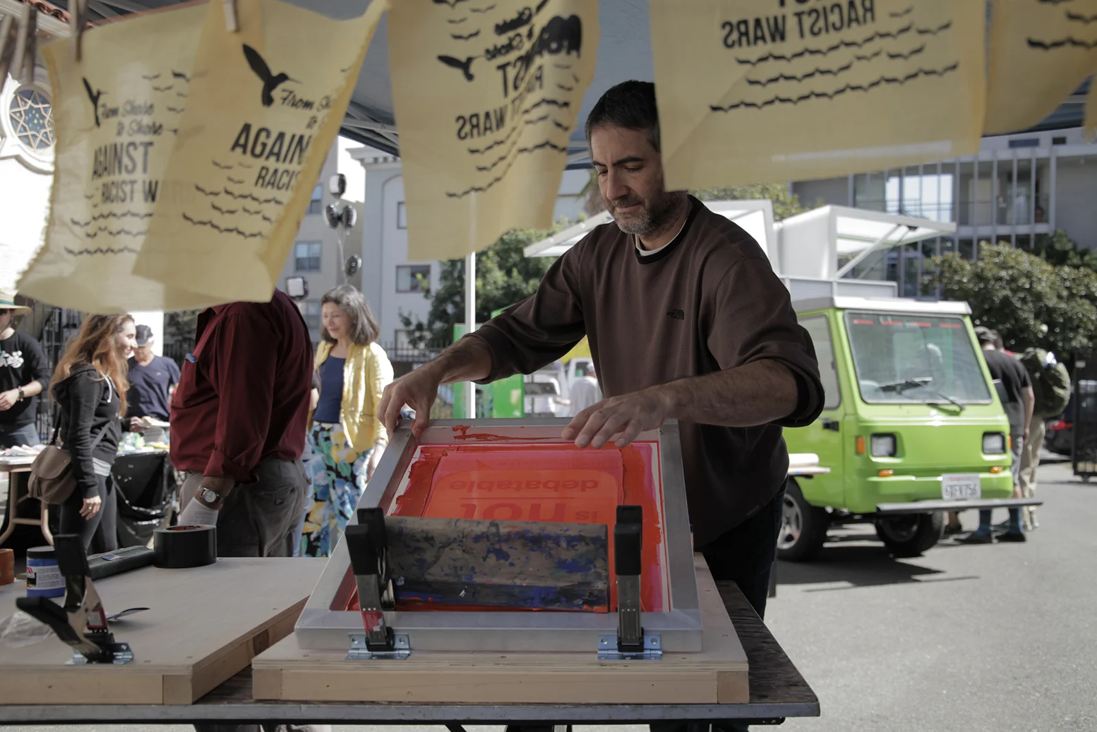 Sami Kitmitto, a member of the Arab Resource and Organizing Center, helps with screen printing. “This is part of our work to oppose racism in the U.S.,” Kitmitto said. - Bay area residents create art protesting the Travel Ban. October, 2017.