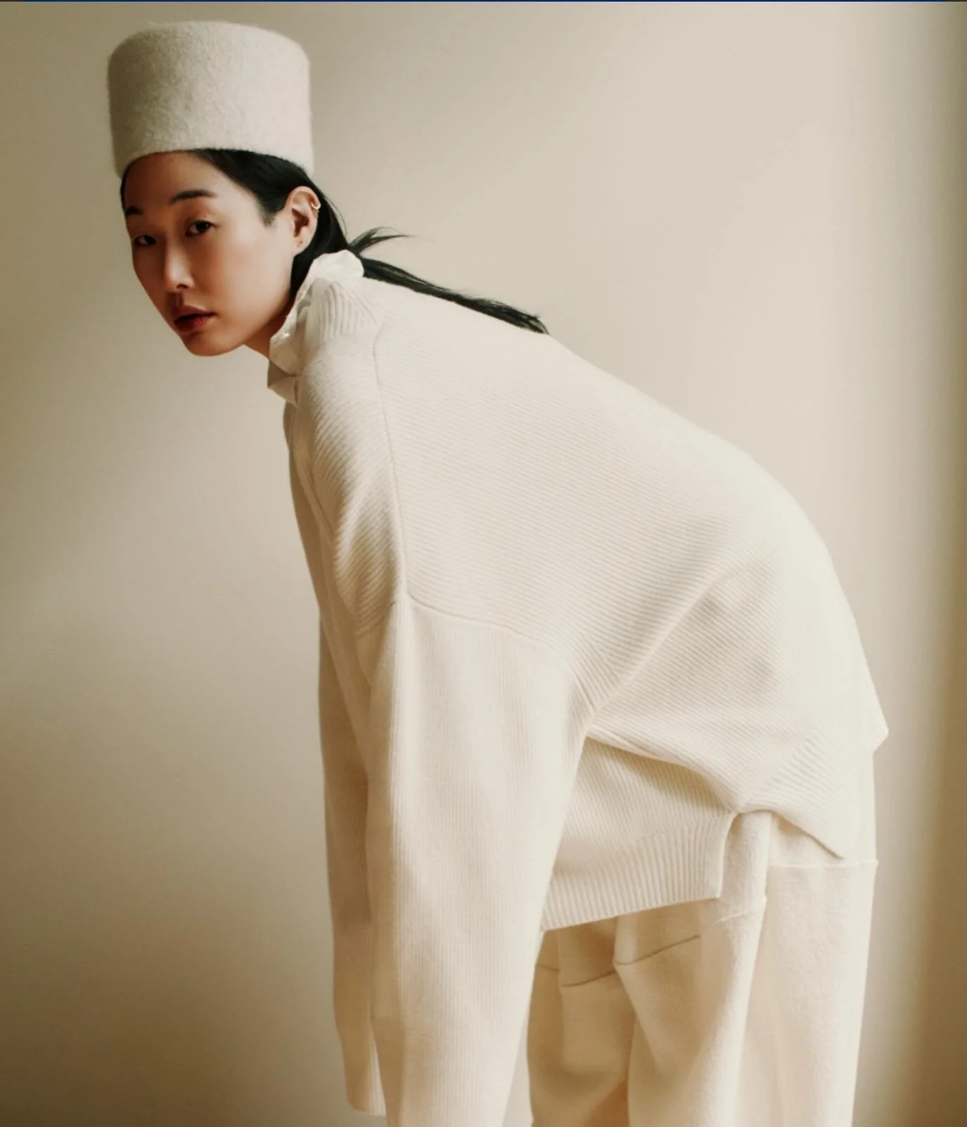A considered oversized silhouette with dropped shoulders and voluminous sleeves that extend past the fingertips, finished with thumb openings. Side slits allow the piece to move easily with the body.