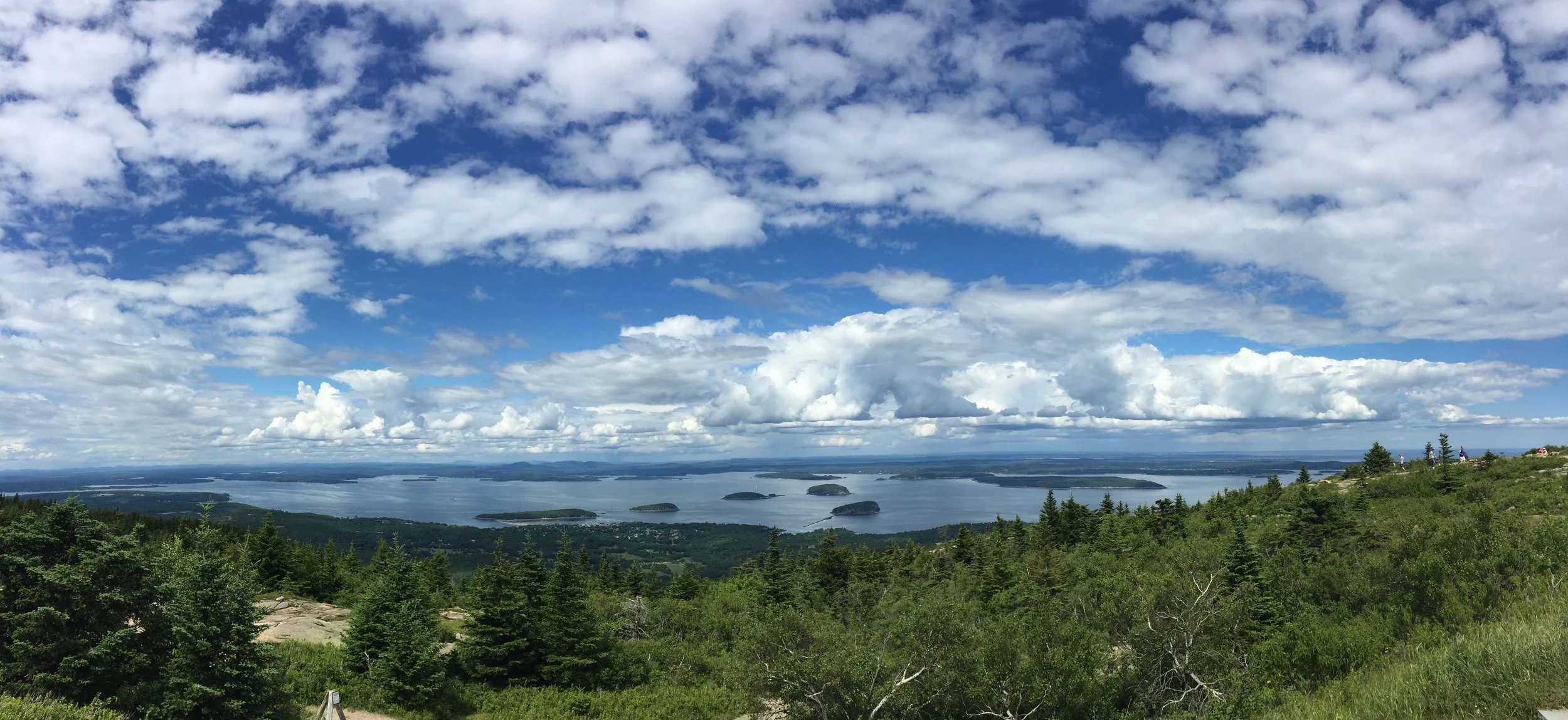 This photo displays the view from atop Cadillac Mountain in Acadia National Park in Bar Harbor, Maine. Peering across the Frenchman Bay, spotted with many little islands, we seemed to be standing above the clouds.
