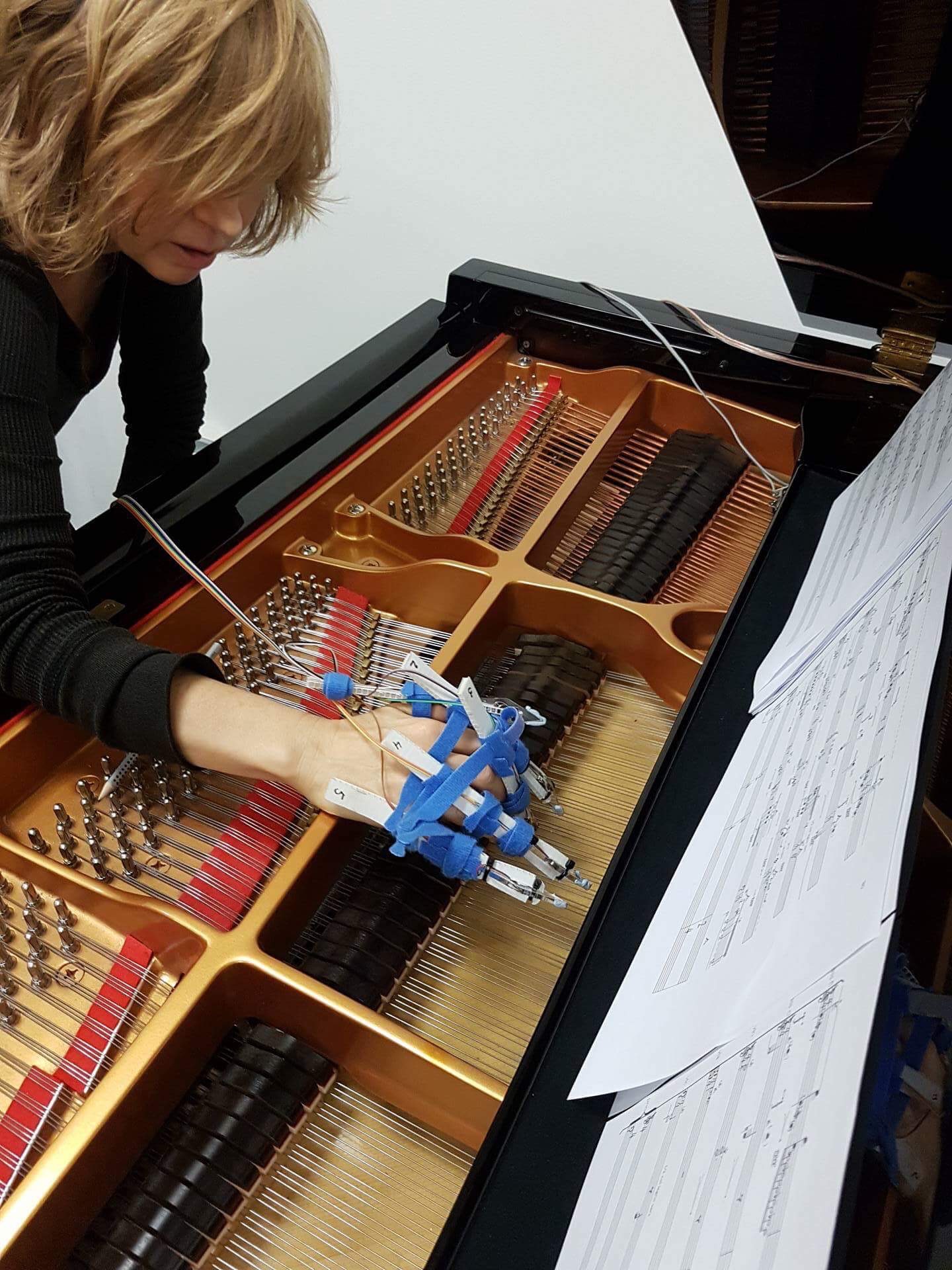 Patricia with the "cyborg" hand prototype of the string excitation robot
