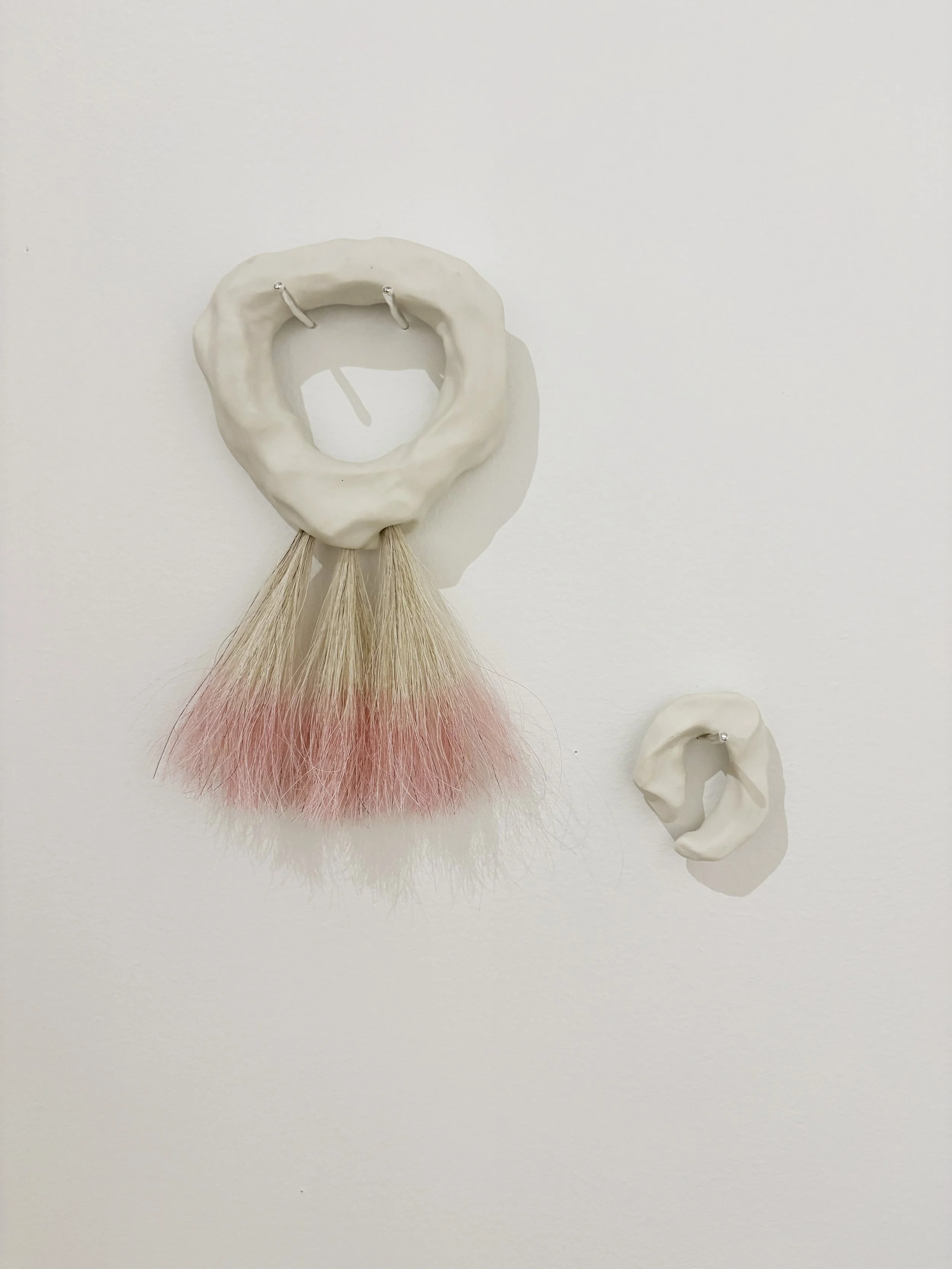   Becoming Tools , 2026, porcelain, horsehair, dye, sterling silver, variable sizes (two pieces) 