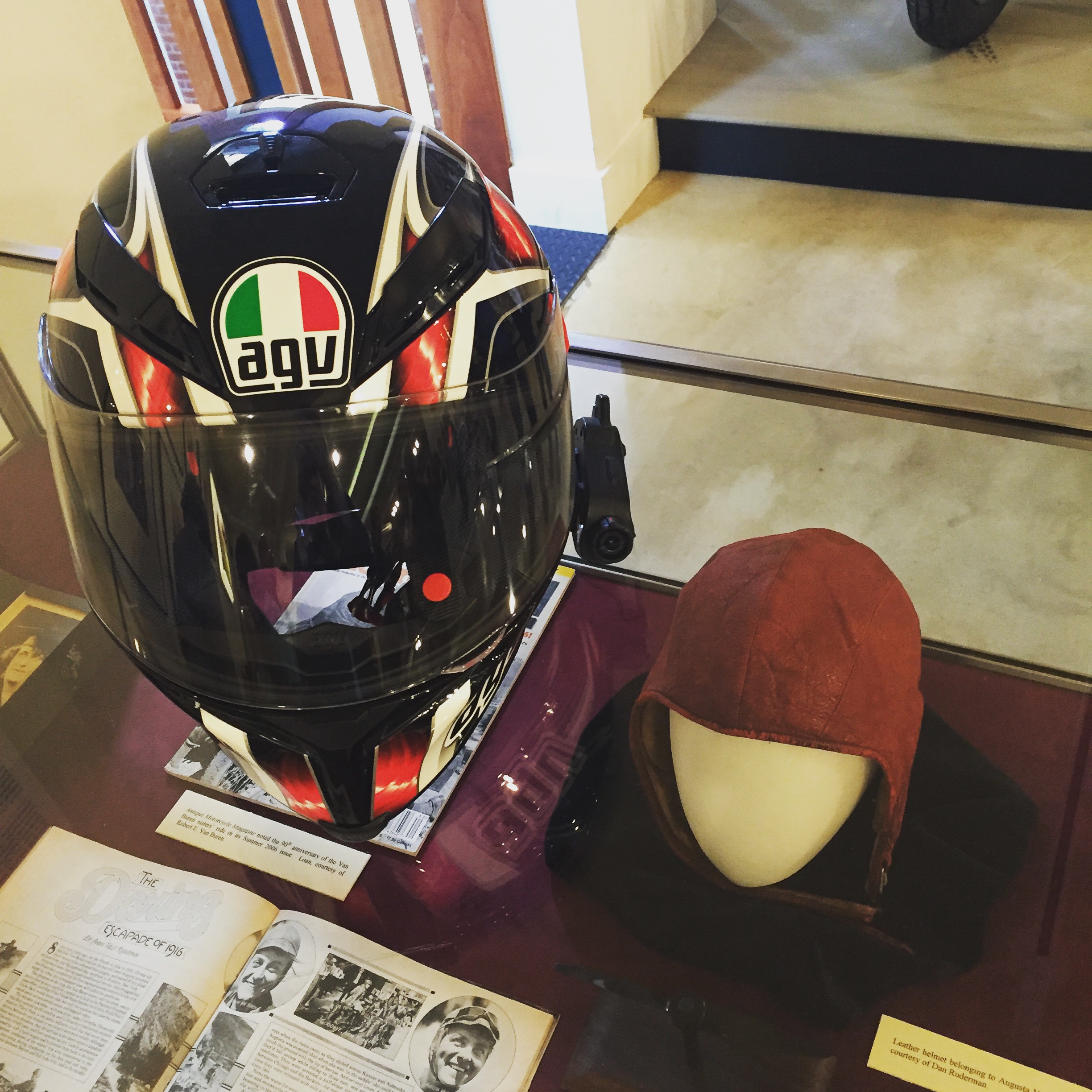 Erin Sills (SheEmoto) AGV Helmet next to Augusta's cap. Her head was SO tiny. (Photo: Me)