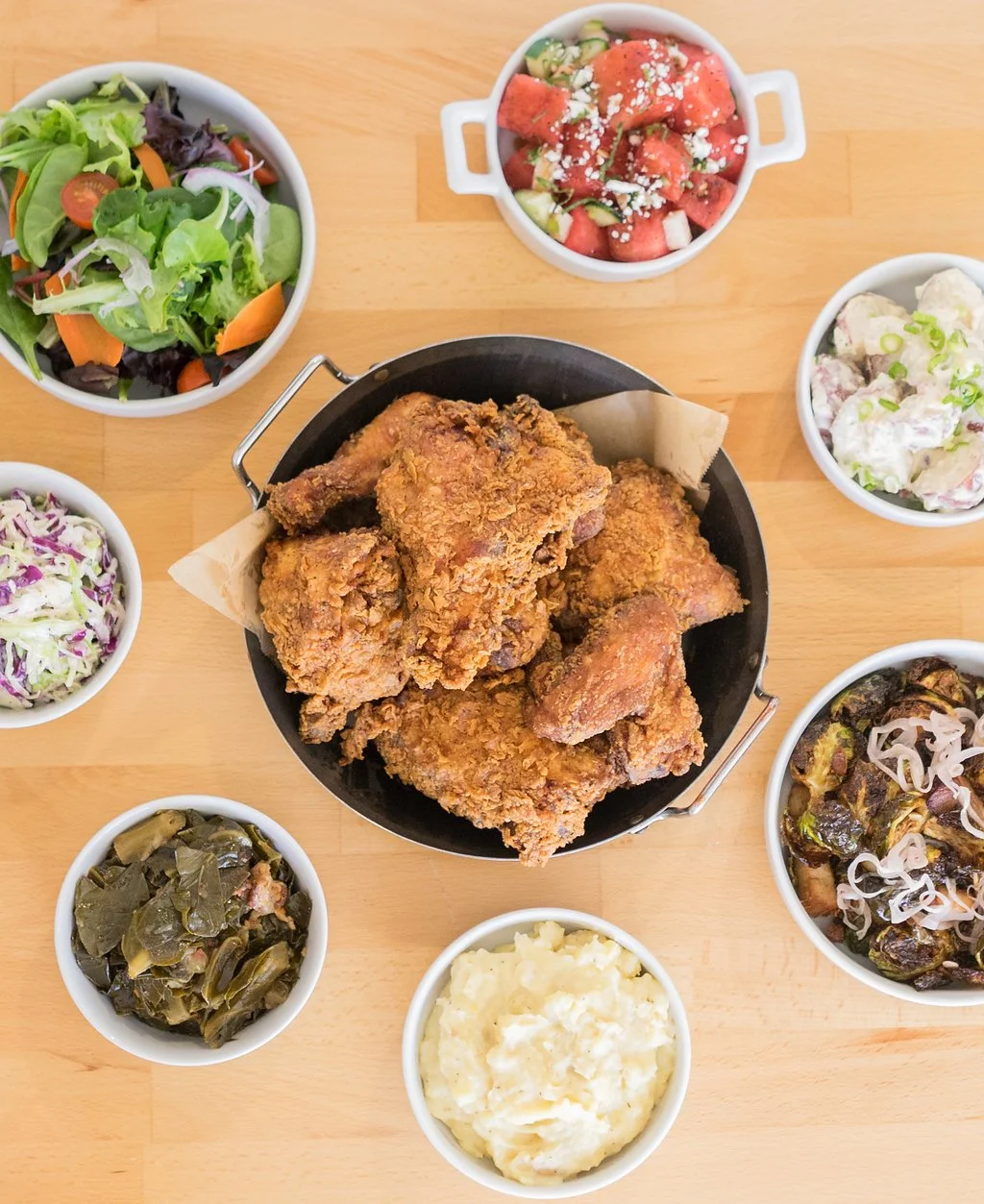 Large catering spread with fried chicken, rice, and sides arranged buffet-style