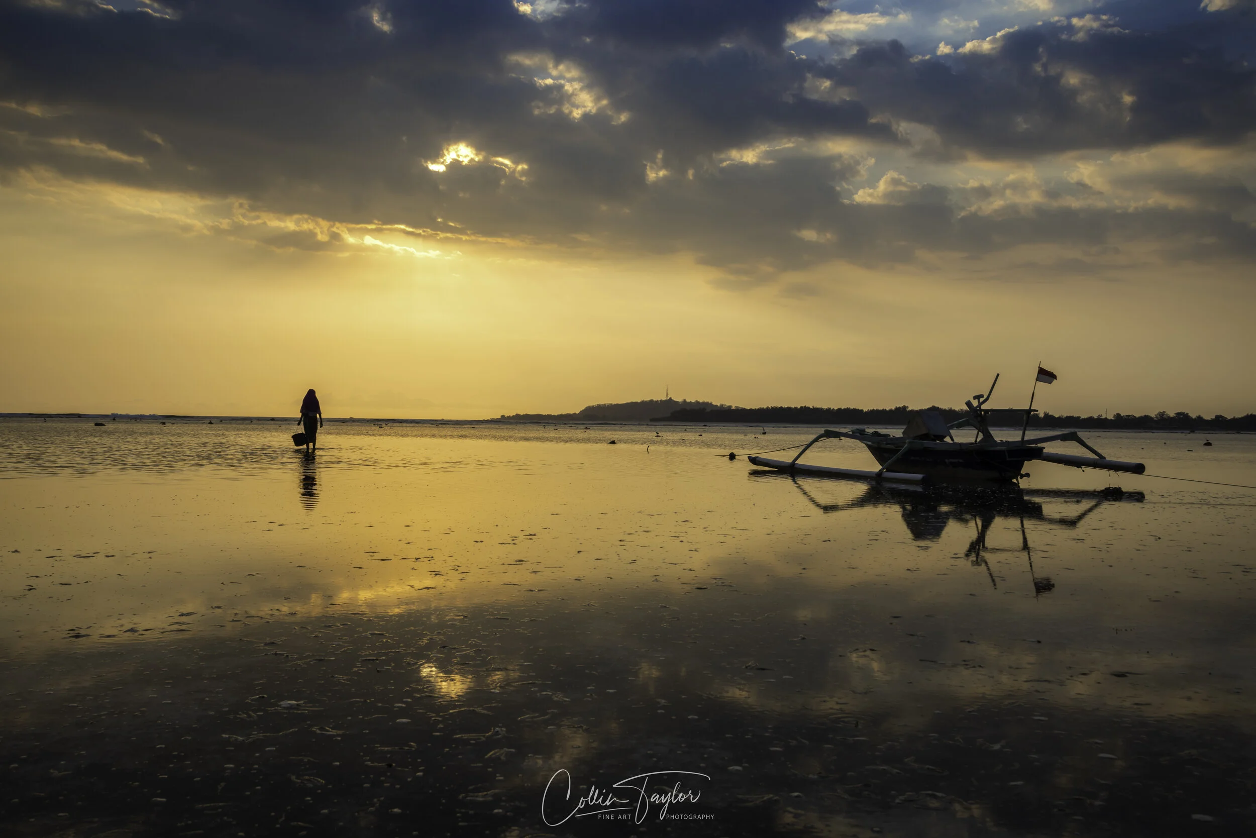 Woman collecting urchins at sunset - Gili Air, Indonesia