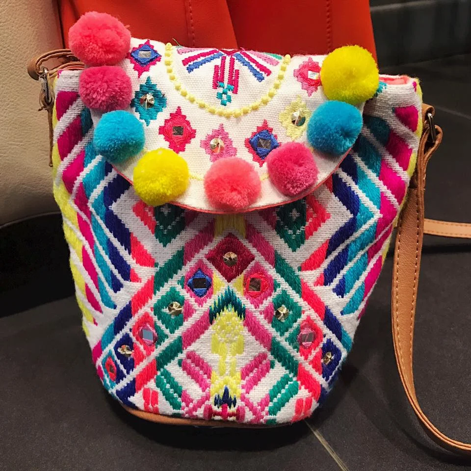 6. Rainbow colours Embroidered sling bag with pom-poms