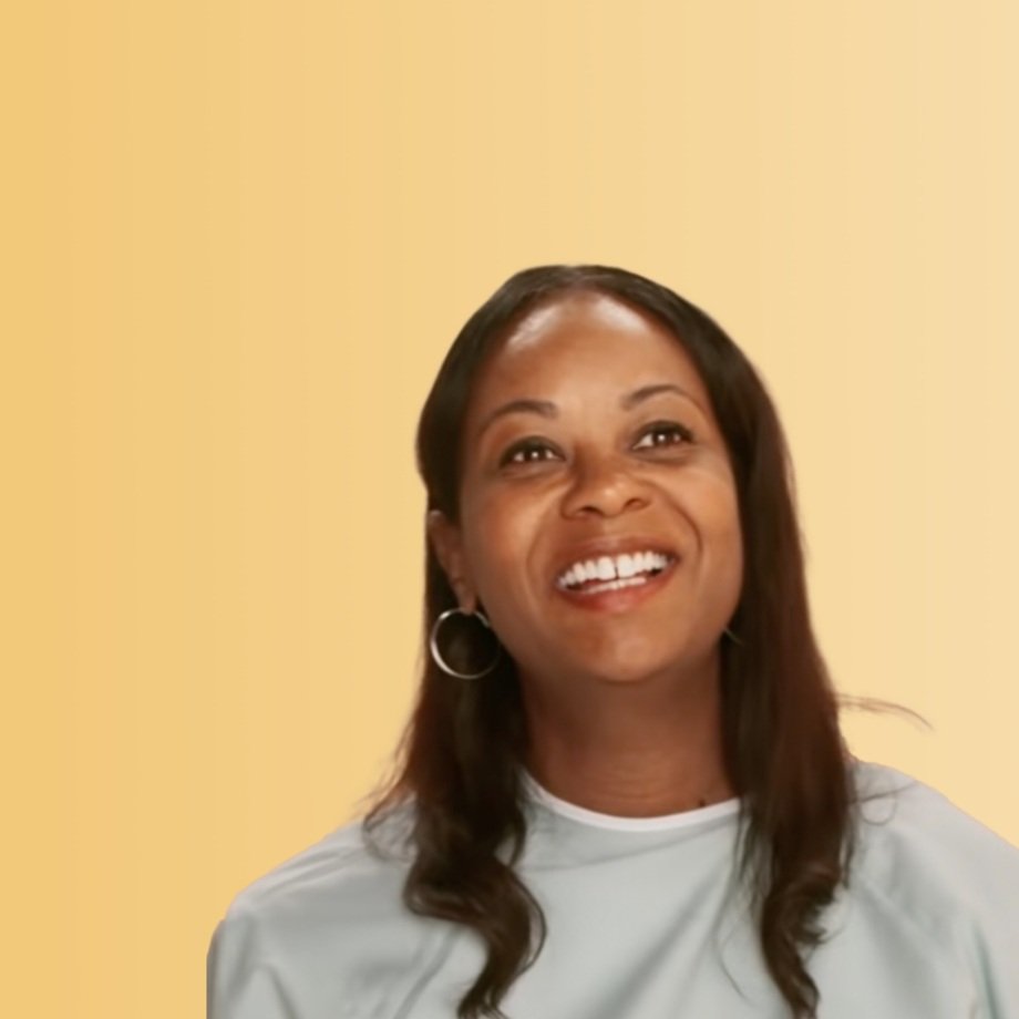 Black woman wearing light blue hospital gown, looking slightly upward