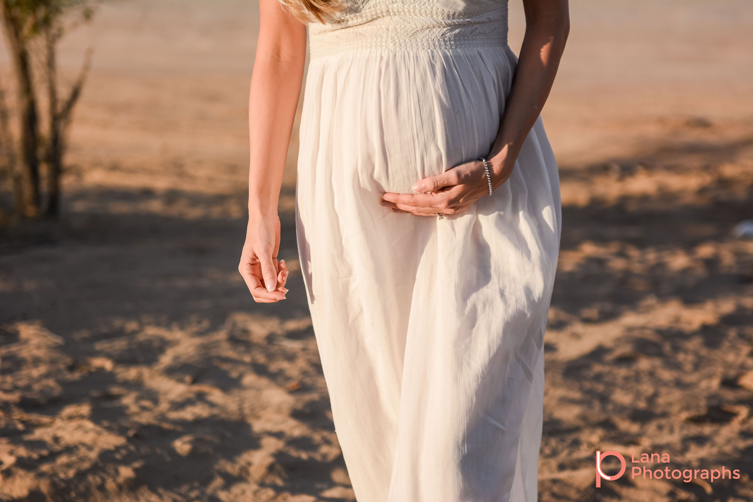 Dubai Maternity Photography portrait of pregnant woman's belly as she is walking towards camera in the desert