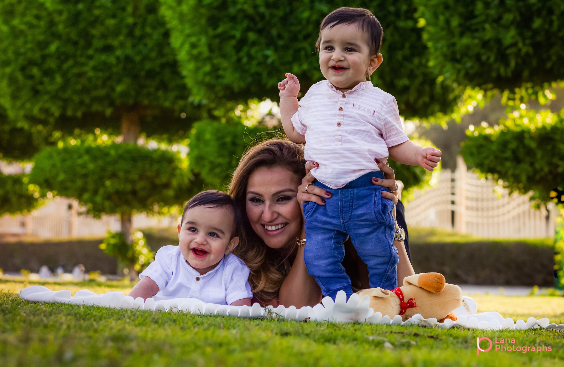 Dubai Family Photography portrait of mother posing with her twins in the grass in the park