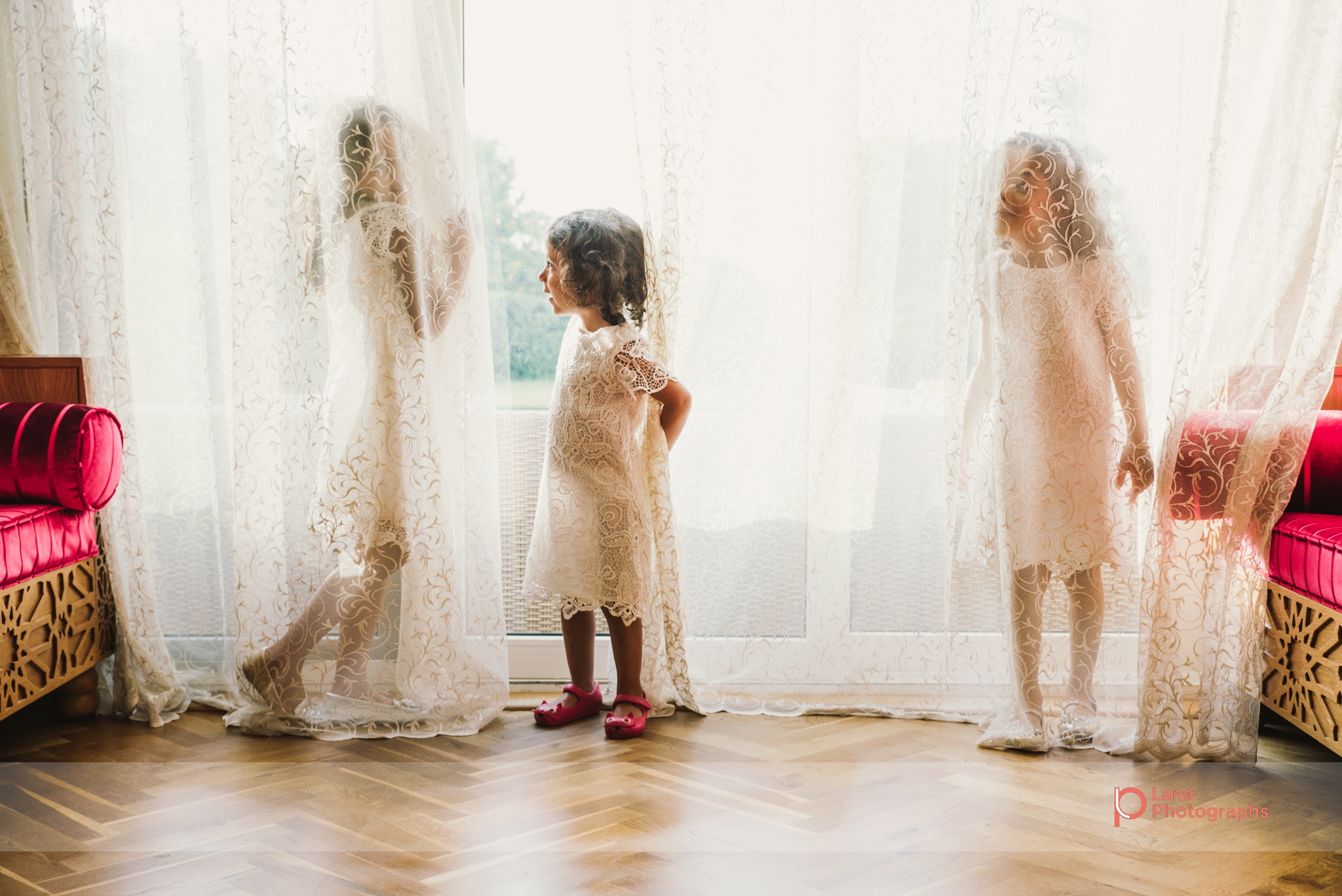 Lana Photographs Family Photographer Dubai Top Family Photographers three girls playing inside the curtains by the window