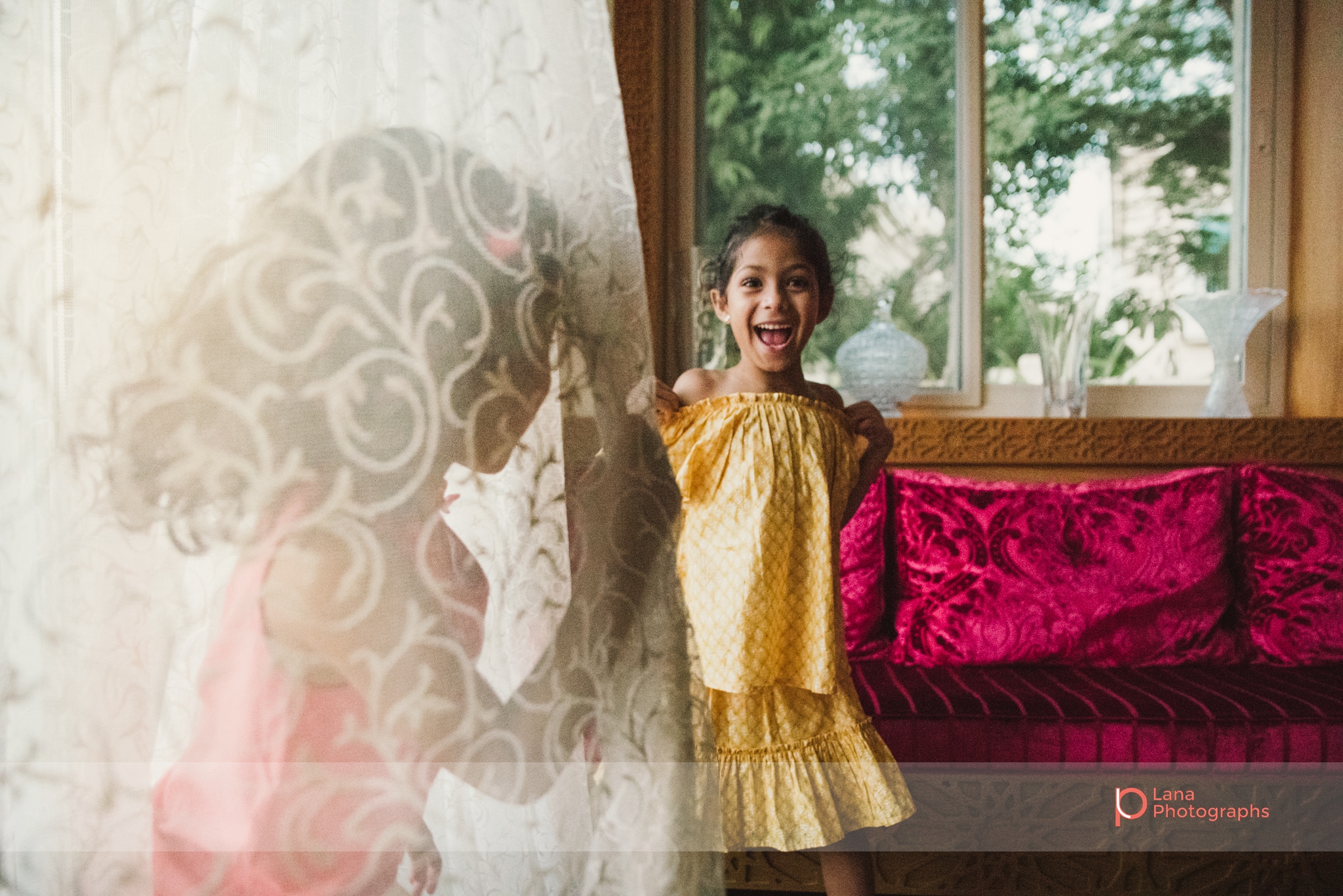 Lana Photographs Family Photographer Dubai Top Family Photographers girl in yellow dress dancing by the window