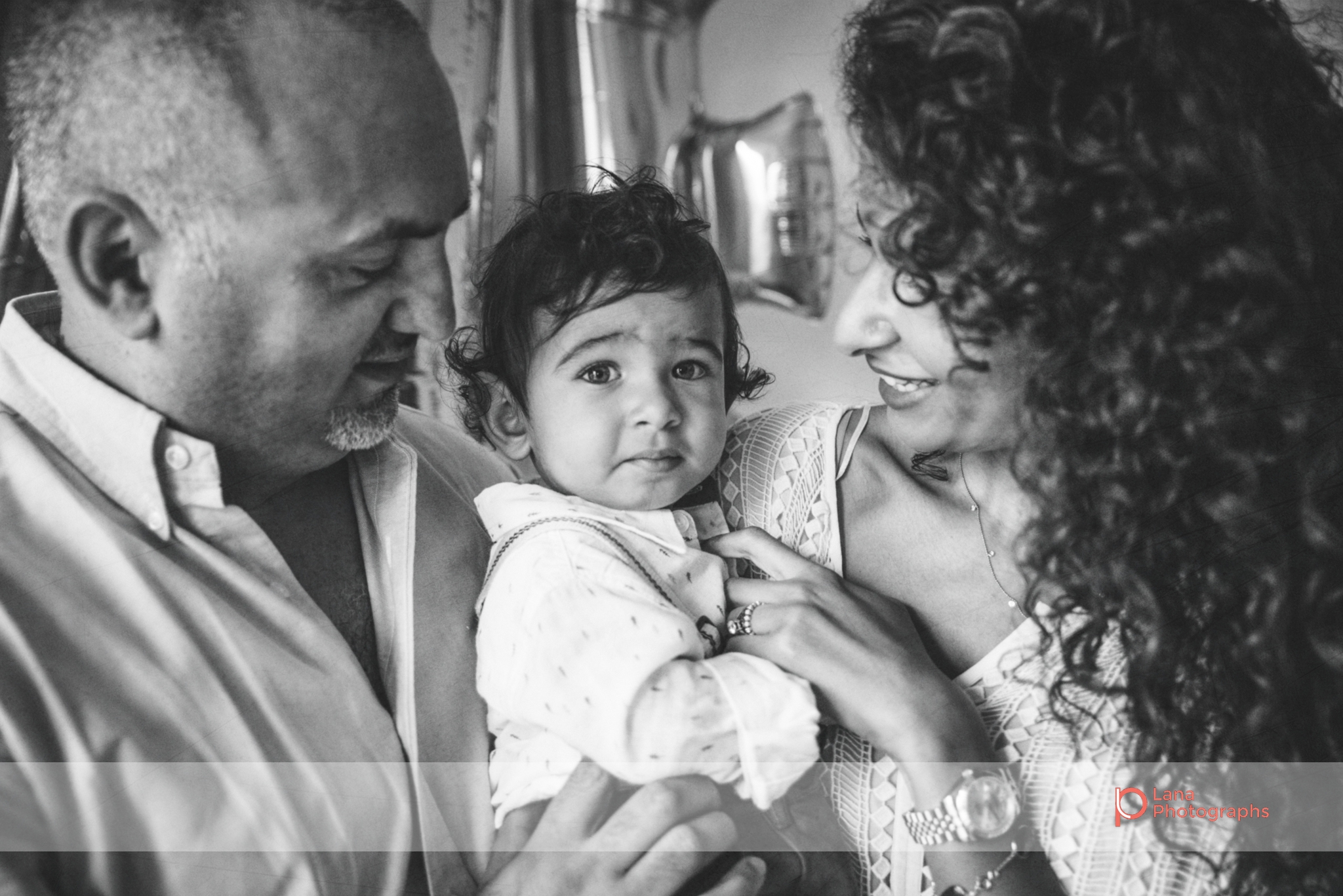 mother and father embrace their one year old baby boy