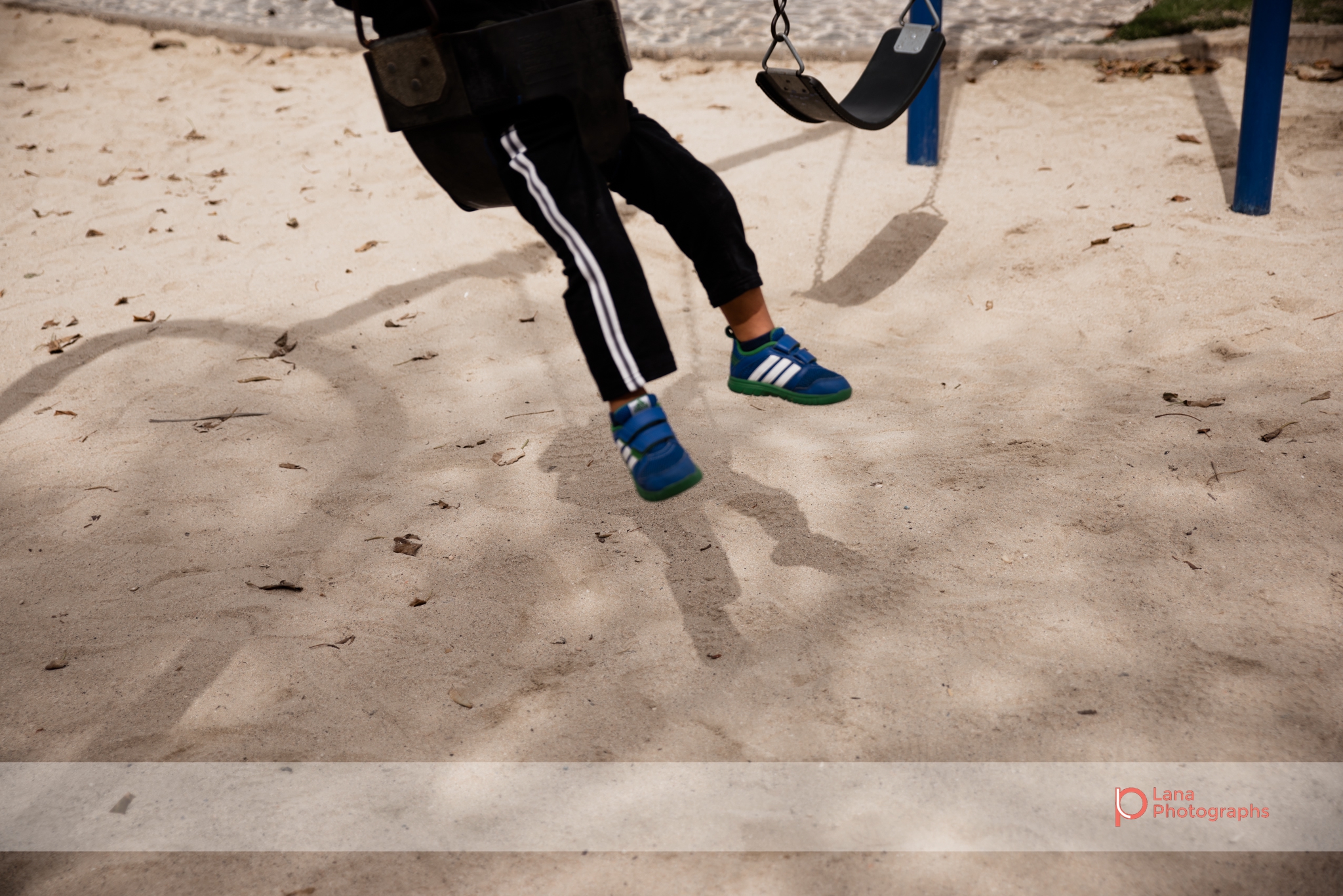 Dubai Family Photographer image of a little boy's legs as he swings on the swings in Umm suqeim park Dubai