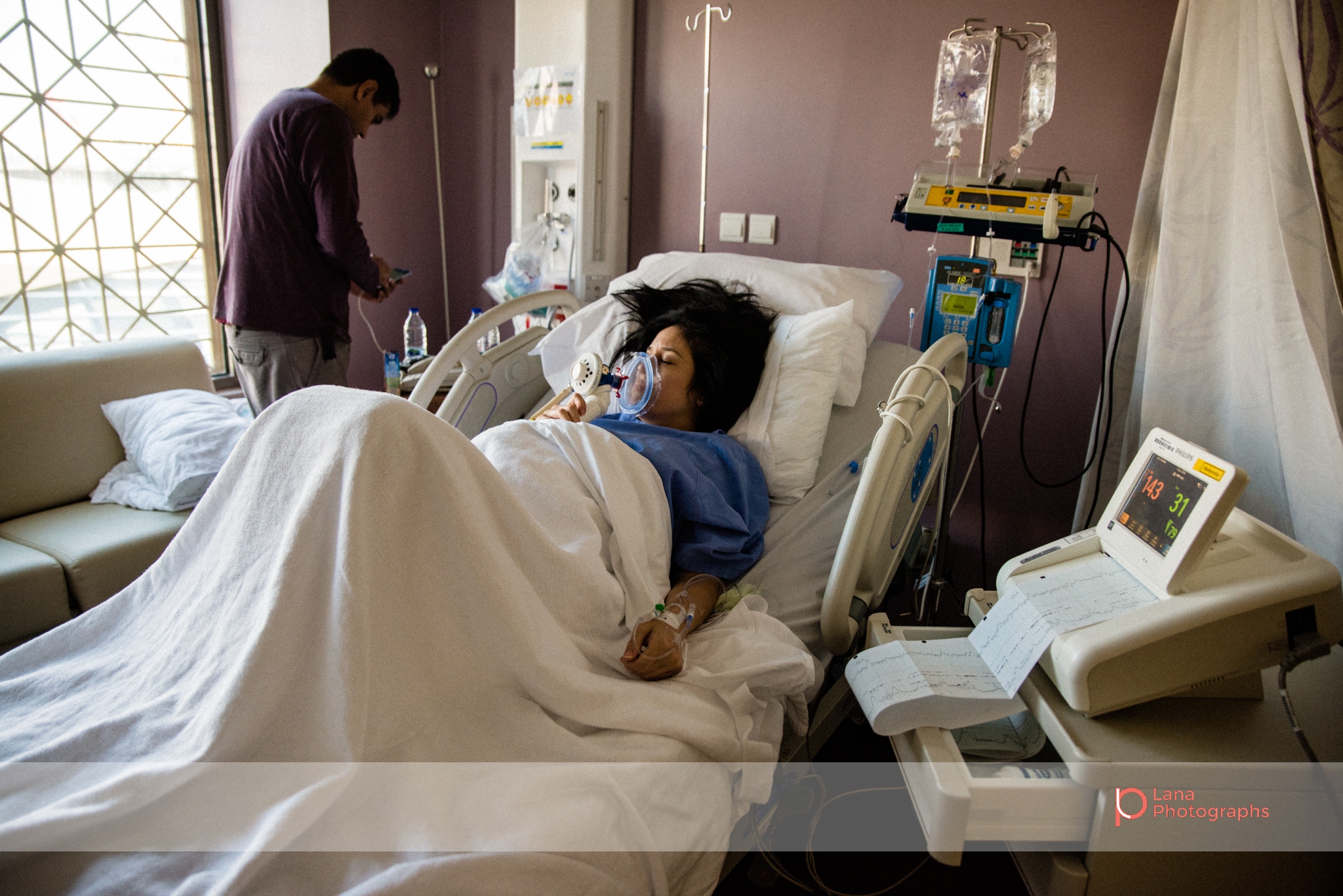 Lana Photographs Birth Photography Dubai Birth photographer dubai birth photography birth photography Mediclinic City Hospital father changing music playlist for mother in labor