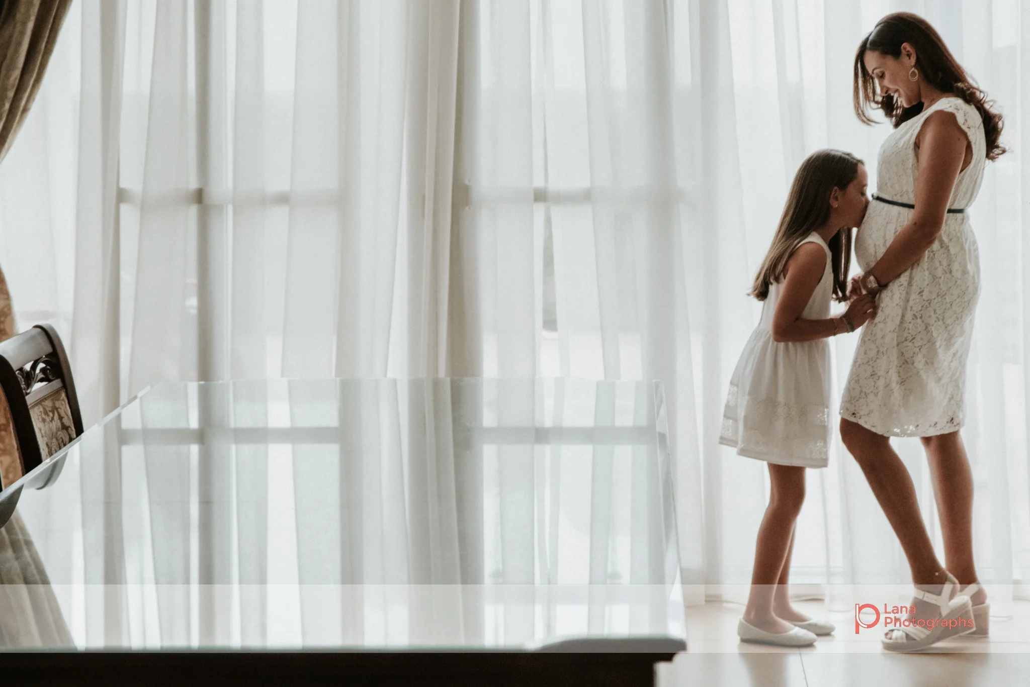 Lana Photographs Maternity Photography Dubai Professional Maternity Photographer daughter kissing her mom's pregnant belly