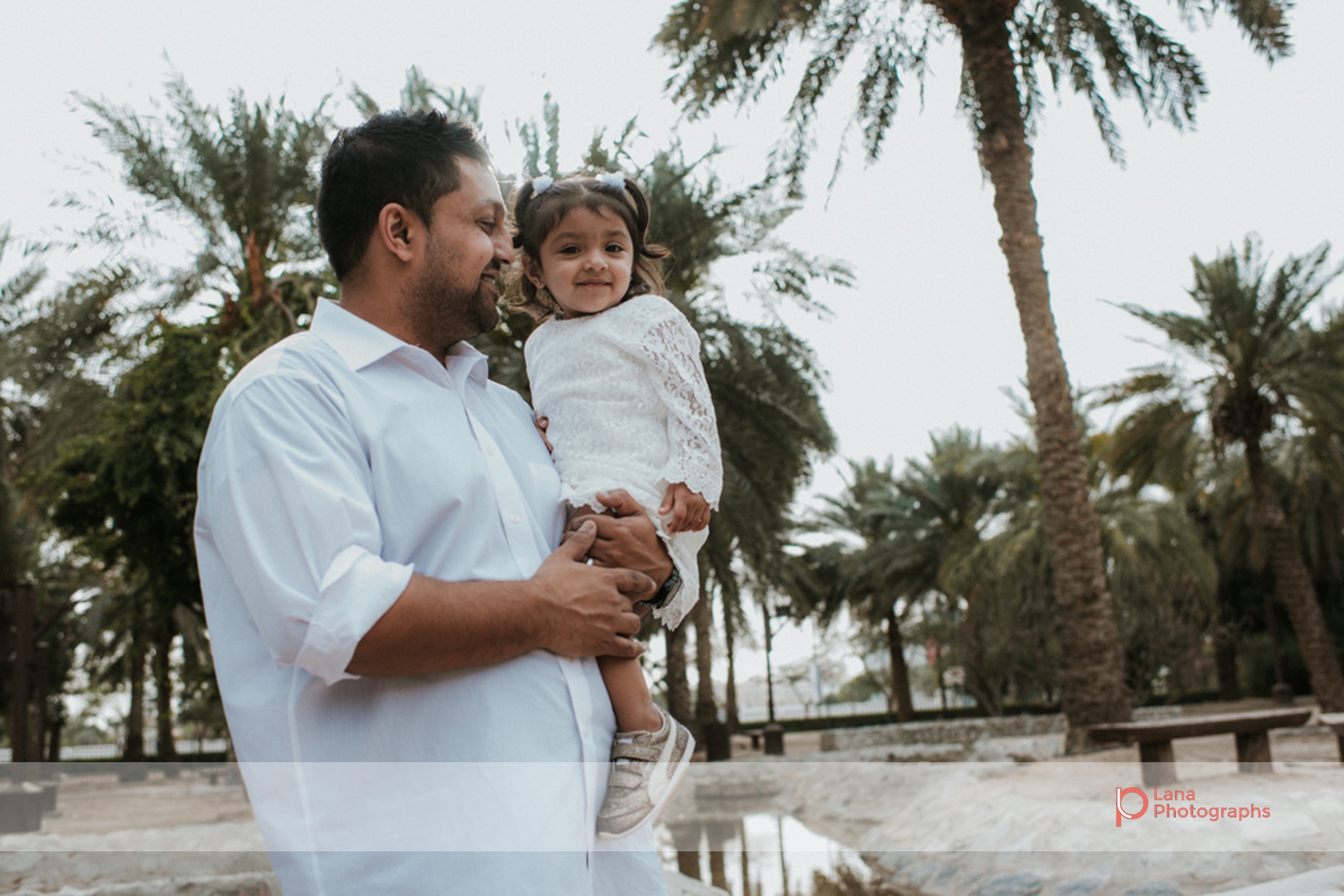 Lana Photographs Family Photographer Dubai Top Family Photographers father carrying girl under palm trees