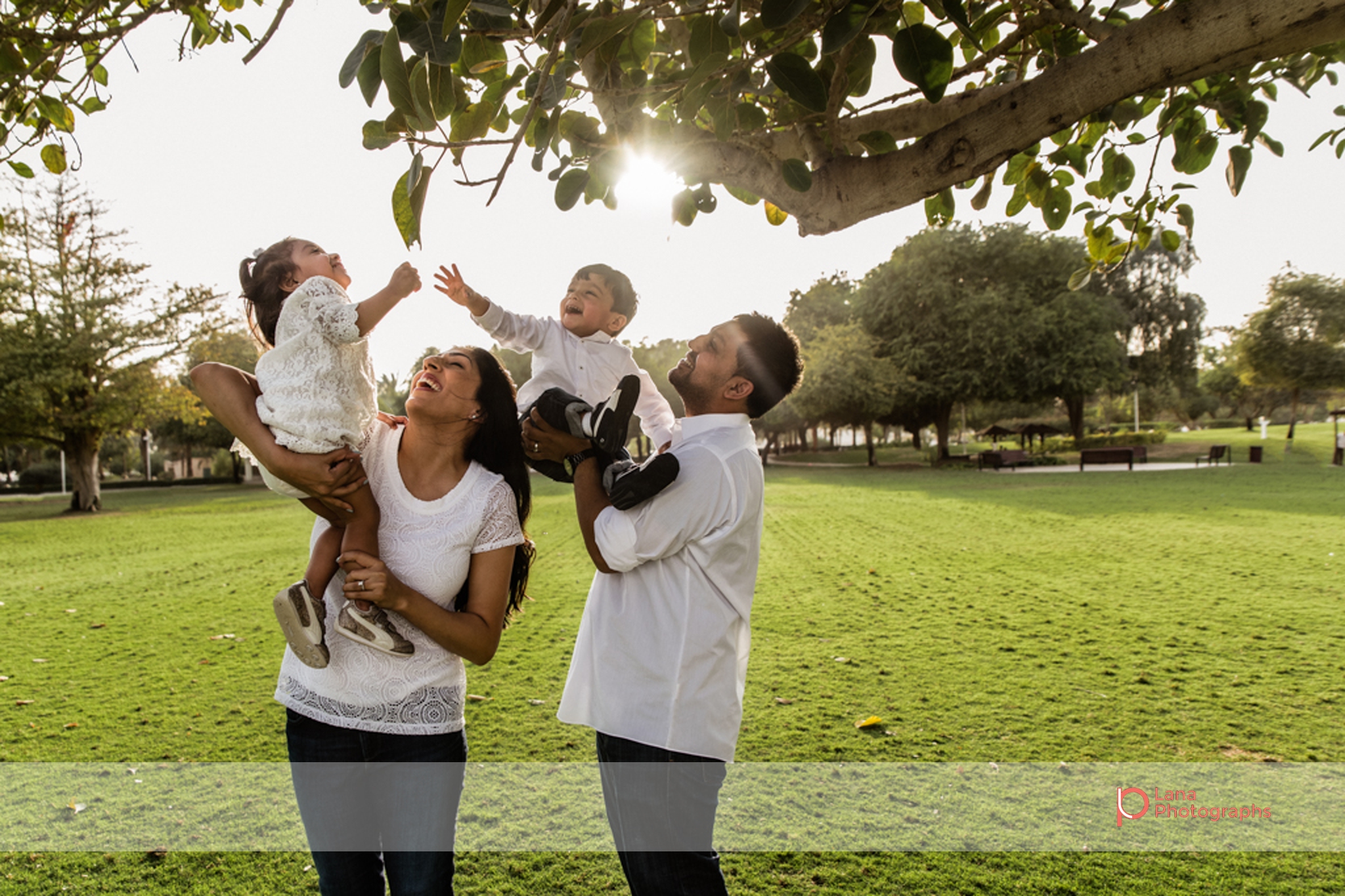 Lana Photographs Family Photographer Dubai Top Family Photographers family playing under the tree in the sunshine