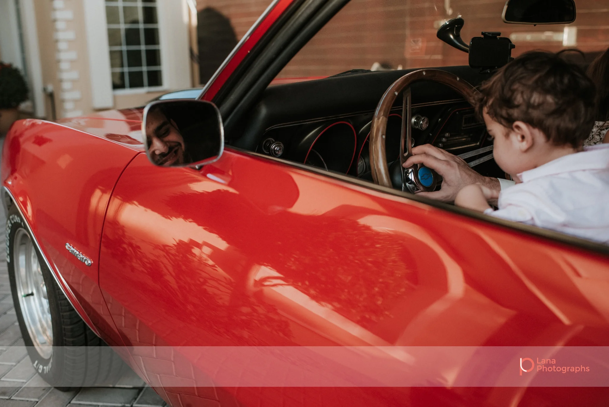 Lana Photographs Family Photographer Dubai Top Family Photographers portrait of father and son riding Camaro ss68