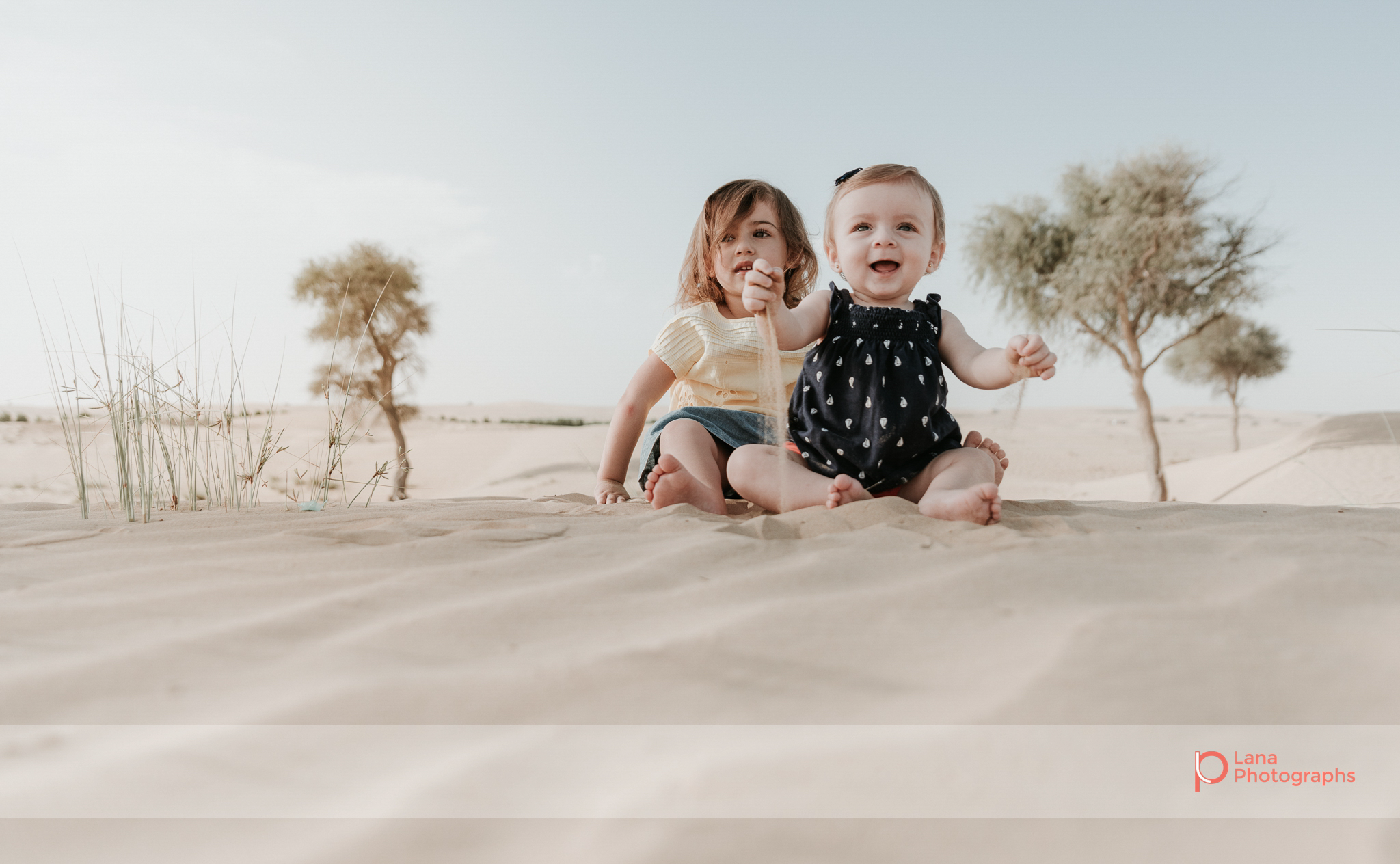 Lana Photographs Family Photographer Dubai Top Family Photographers sisters playing in the sand