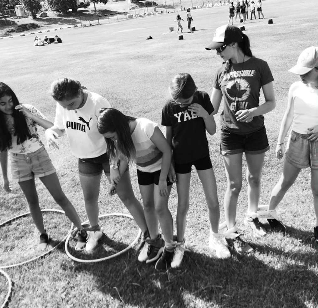 Girls playing team bonding game outside at summer camp