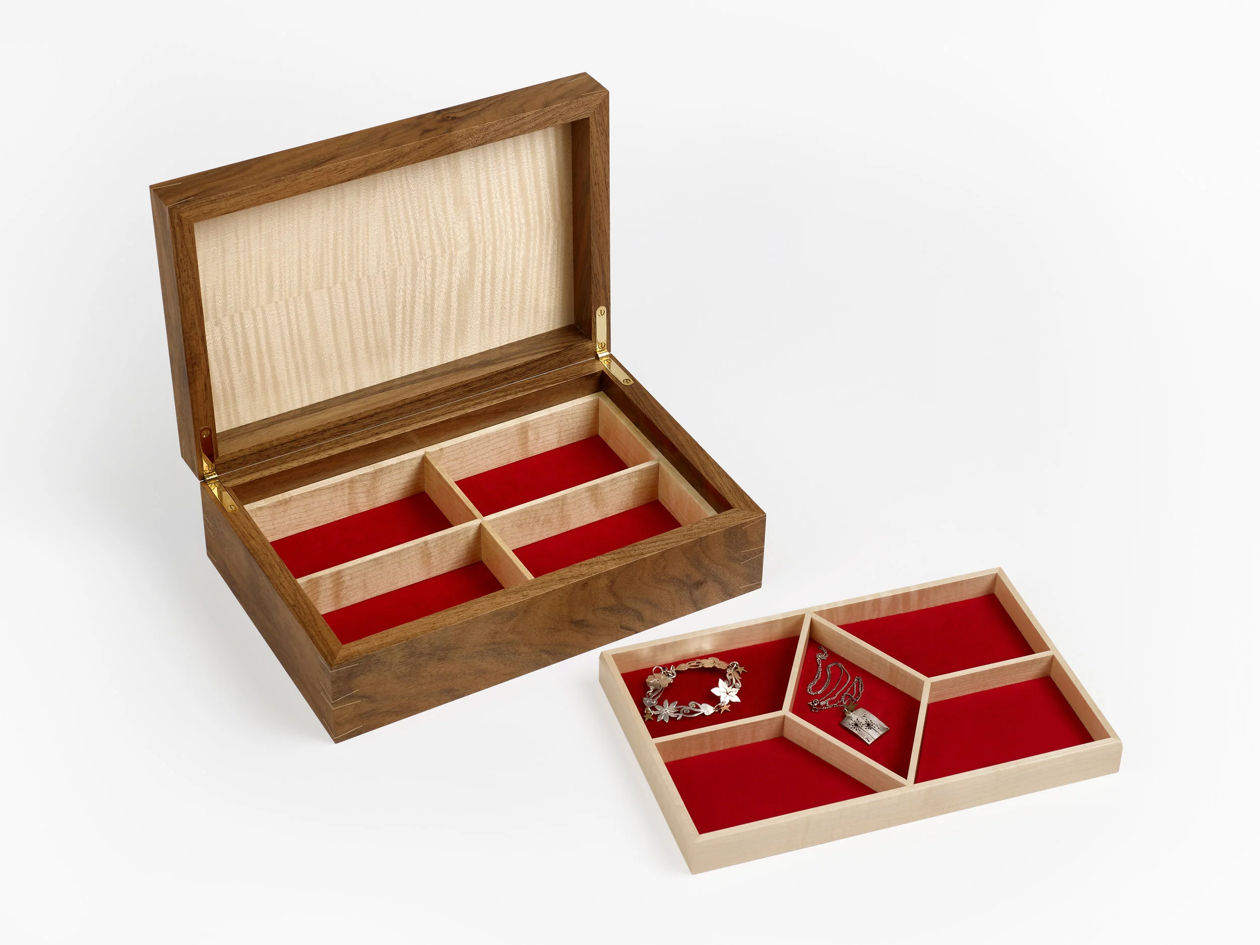  There are four compartments below the lift out tray in ripple sycamore with red suede lined base. 