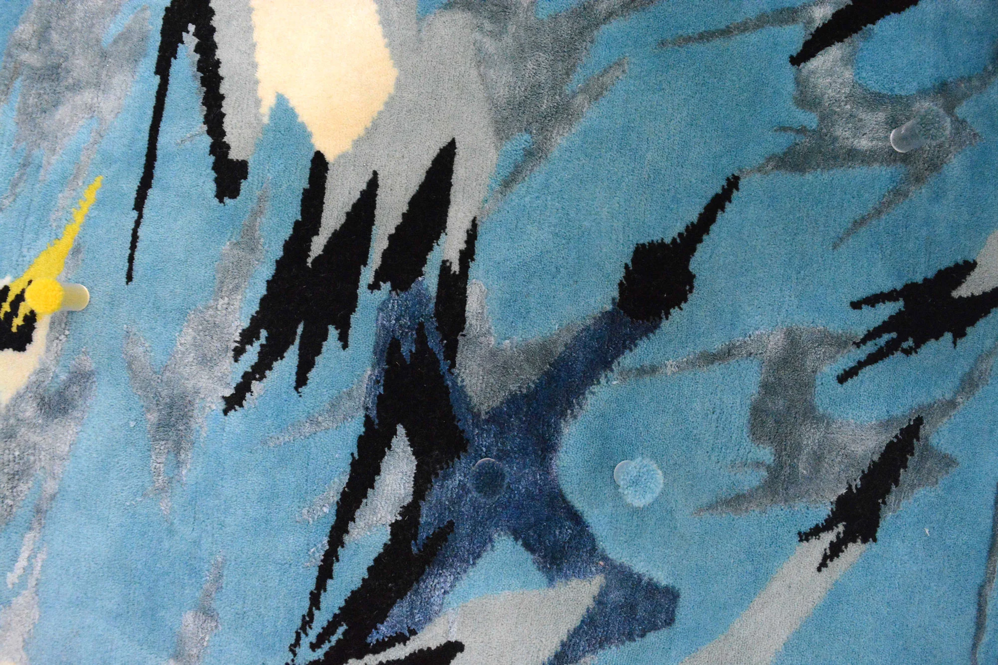 A detail of the finished rug showing how the wool colours are checked against the original design