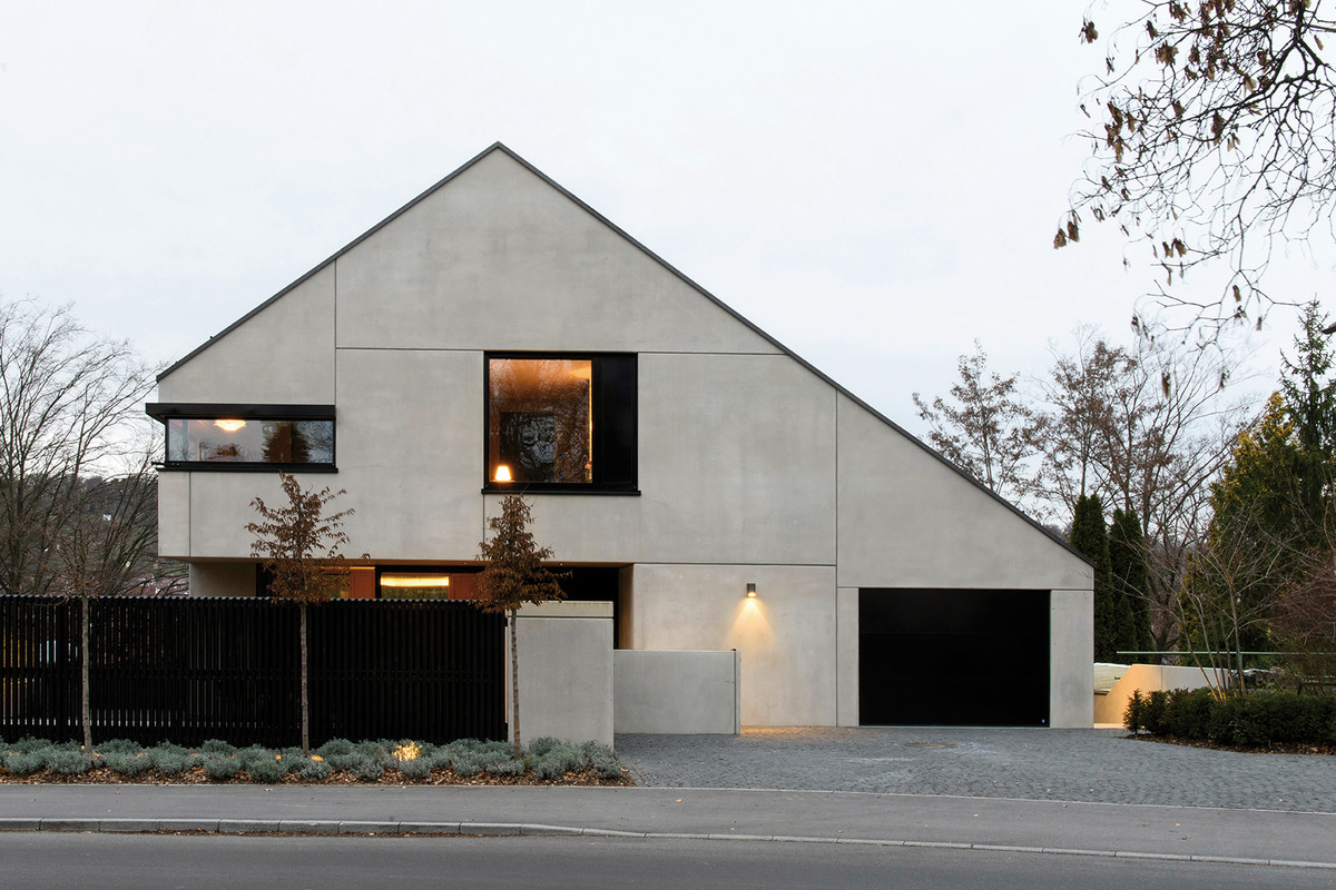 STUTTGART, GERMANY - A spacious house built on a small plot in Stuttgart‘s Feuerbach district. The house is a homogeneous concrete sculpture, surrounded by lush green; from the floor-to-ceiling windows, you have a fantastic view of the vineyards opposite. As a contrast to the cool look of the concrete, the owners wanted natural materials and warm colors inside.