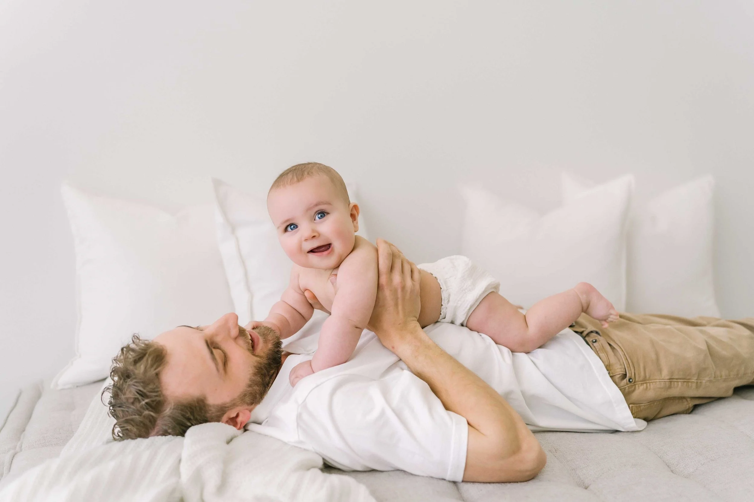 Candid family moment with parents embracing baby during professional photoshoot