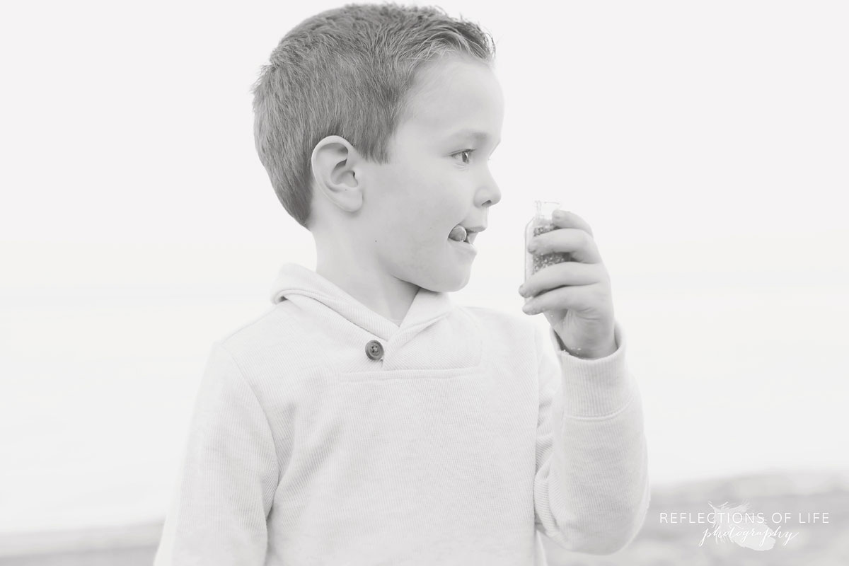 little boy playing with bubbles on the beach in niagara region of ontario canada