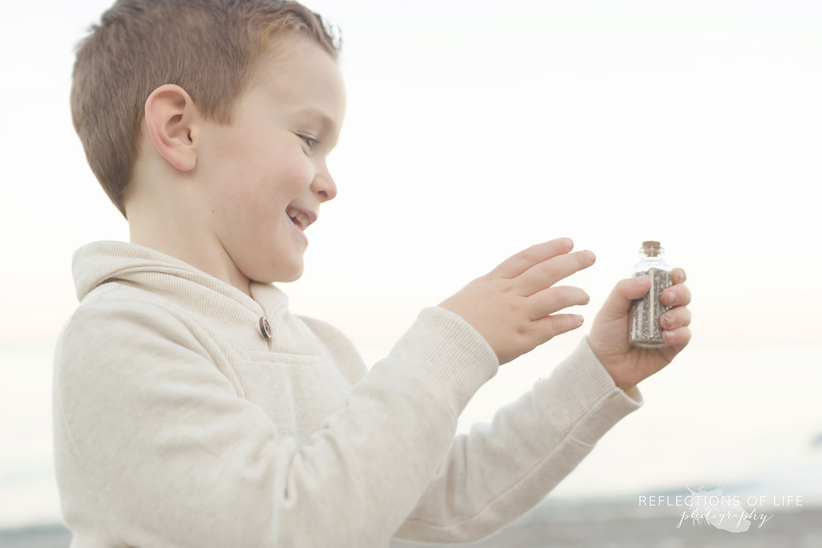 little boy playing with bubbles on the beach in southern ontario canada