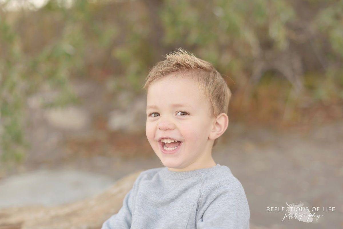 little boy laughing on the beach in southern ontario canada