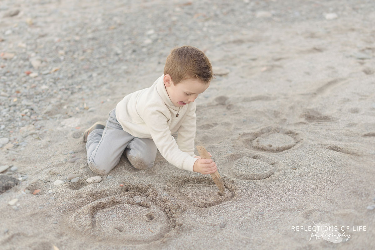 little boy playing on the sandy beach in southern ontario canada