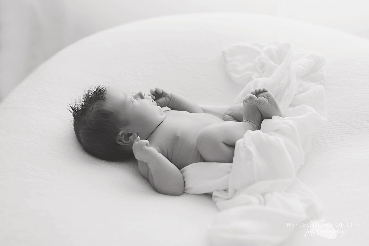 Baby laying down in windowlight bright newborn baby pictures Niagara Region Ontario Canada