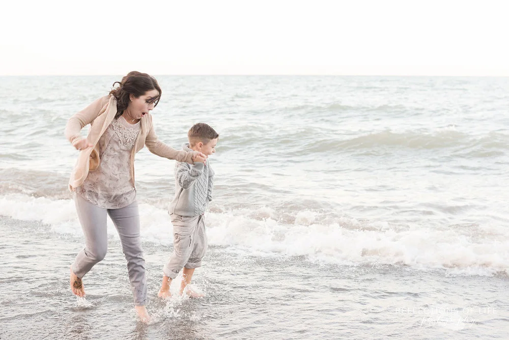 Niagara family photos on the beach mother and son running though the water