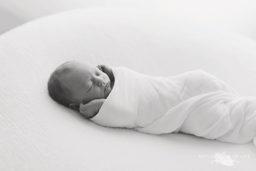 005 Top Ten Favourite Newborn Images baby swaddled in blanket hands out